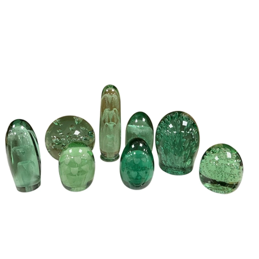 A collection of eight green glass dump paperweights, 19th ce...