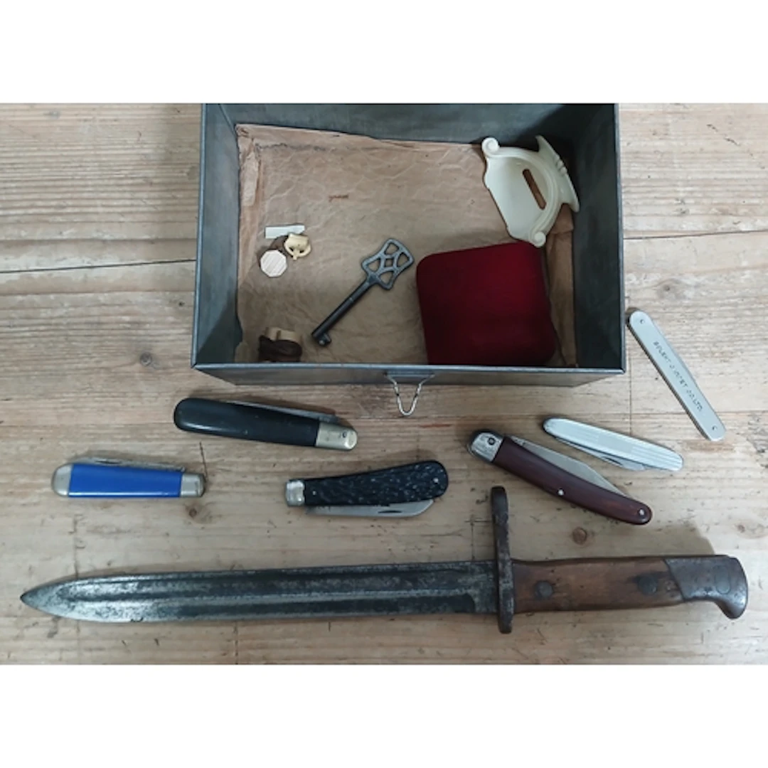 A bayonet and a tin including penknives etc.