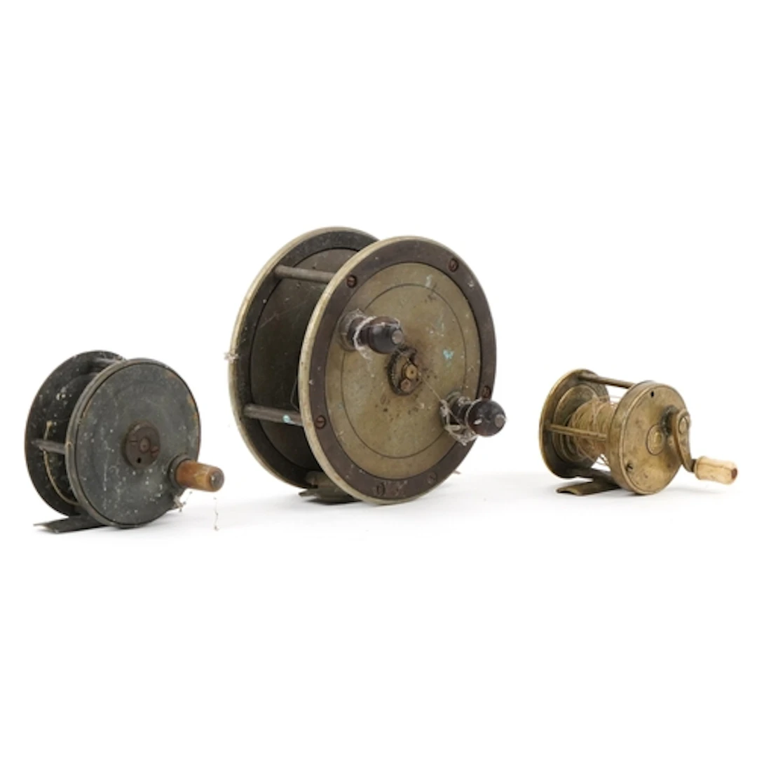Three antique brass fishing reels, the largest 11.5cm in dia...