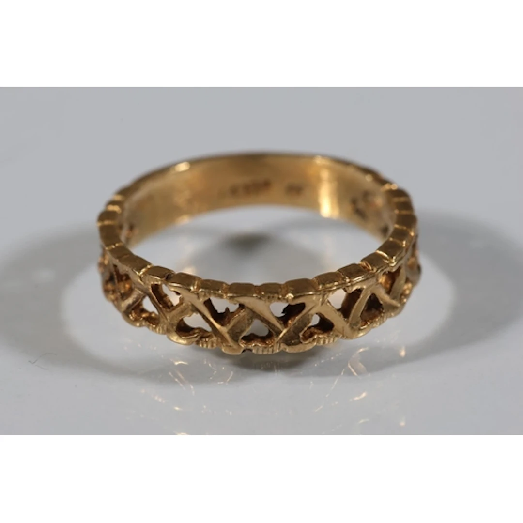 Gold tone ring with pierced heart design, stamped '14K', siz...