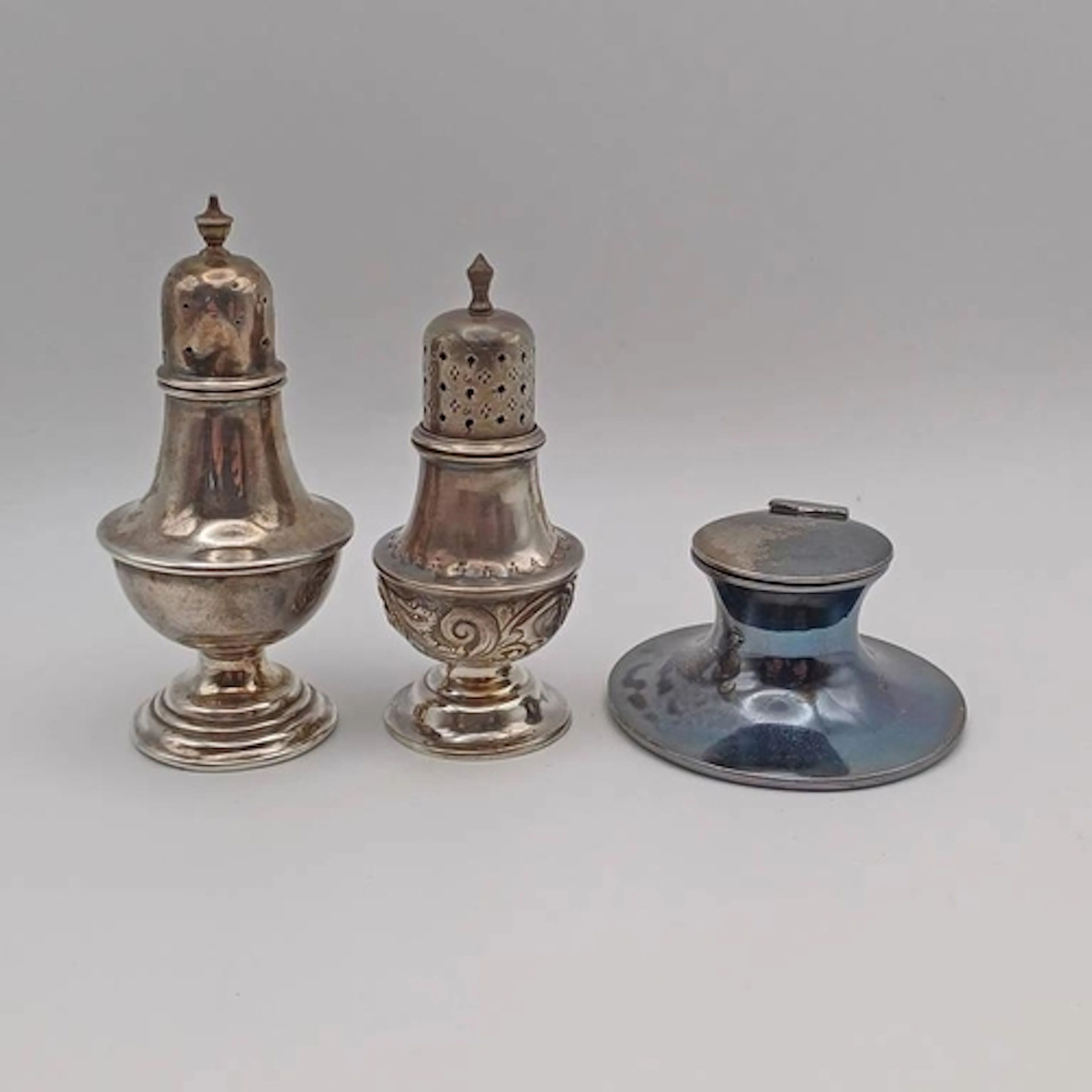 2 SILVER PEPPERS, ONE WITH EMBOSSED DECORATION & A MINIATURE...
