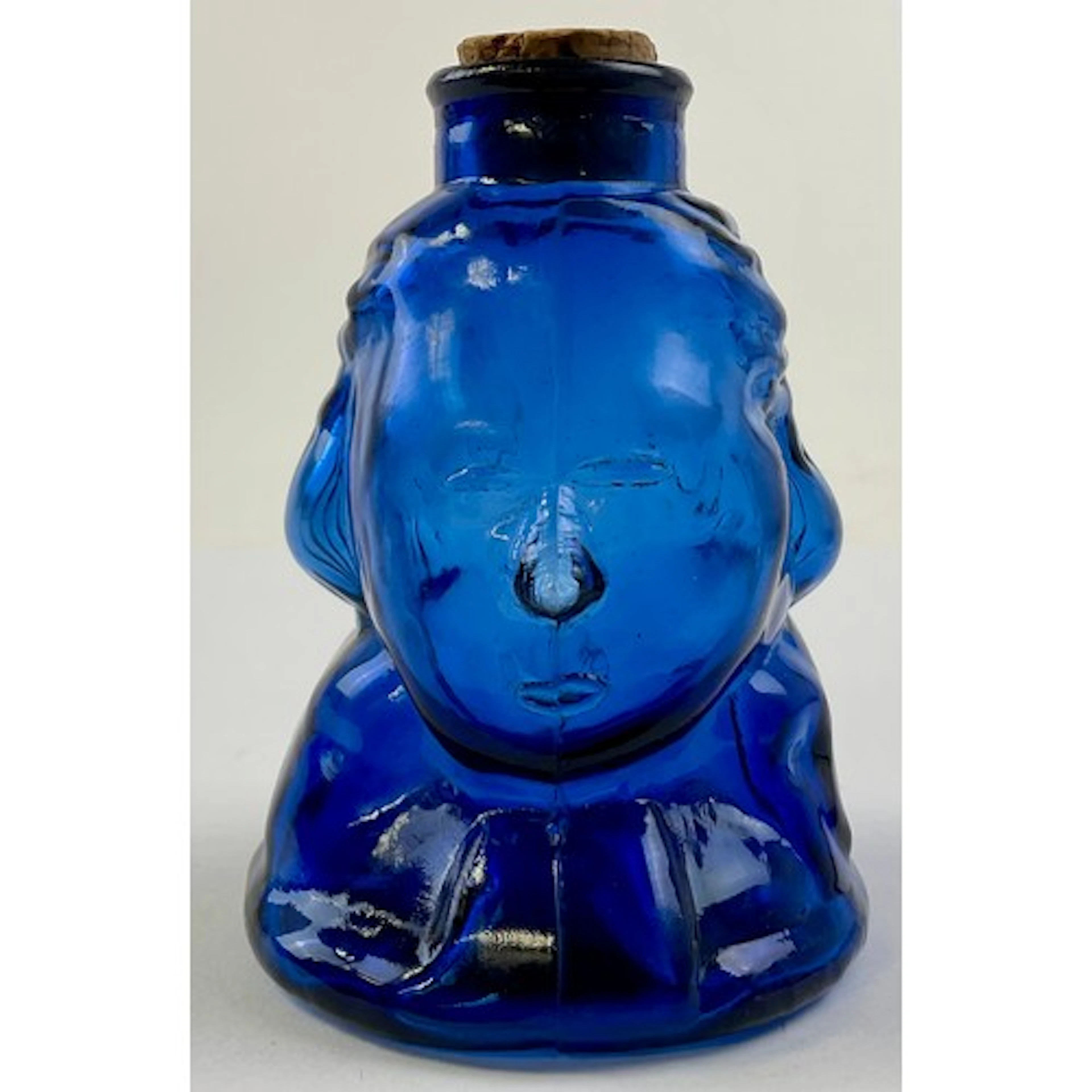 A blue glass bottle, modelled as a portrait bust of George W...