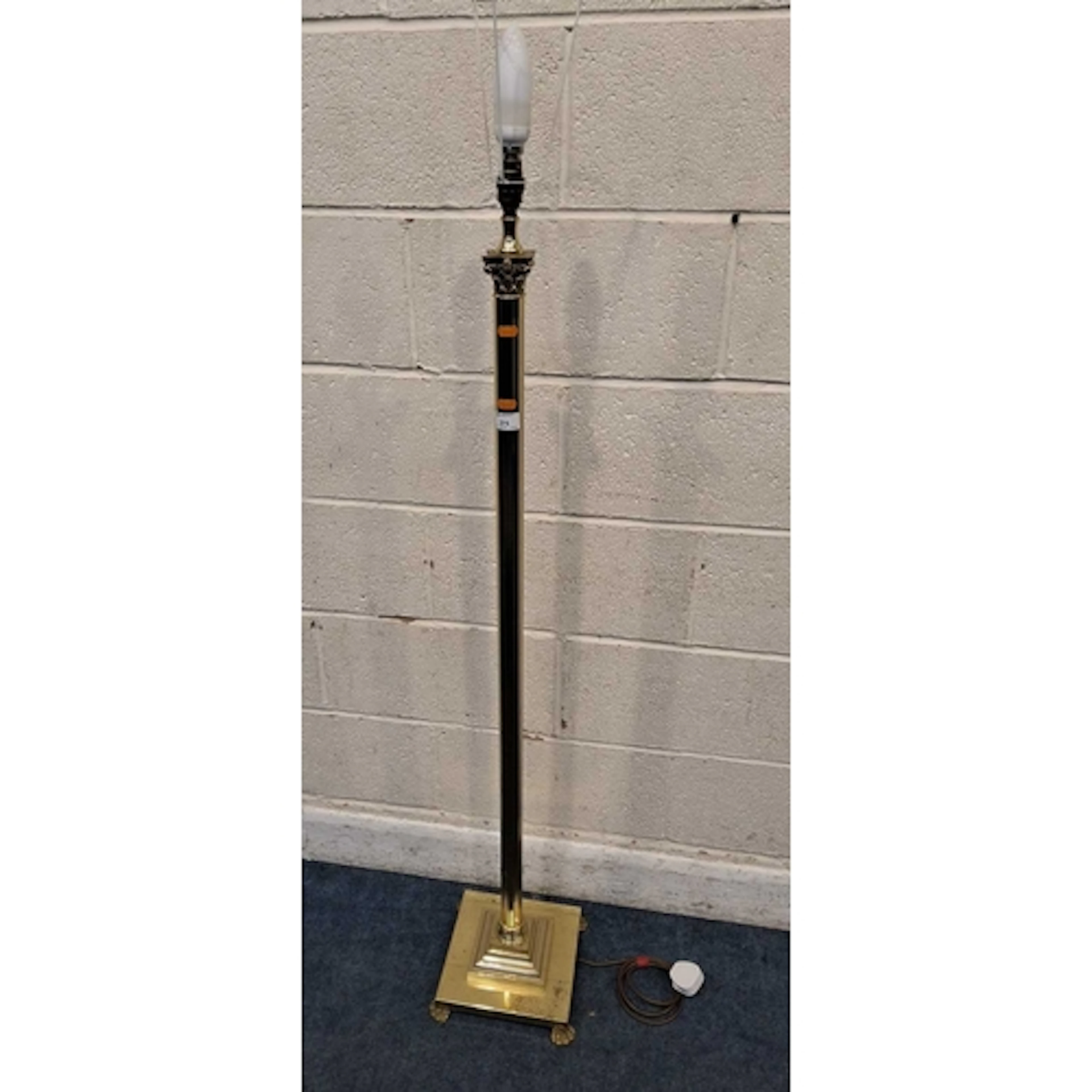 A BRASS CORINITHIAN STYLE STANDARD LAMP, with a square stepp...