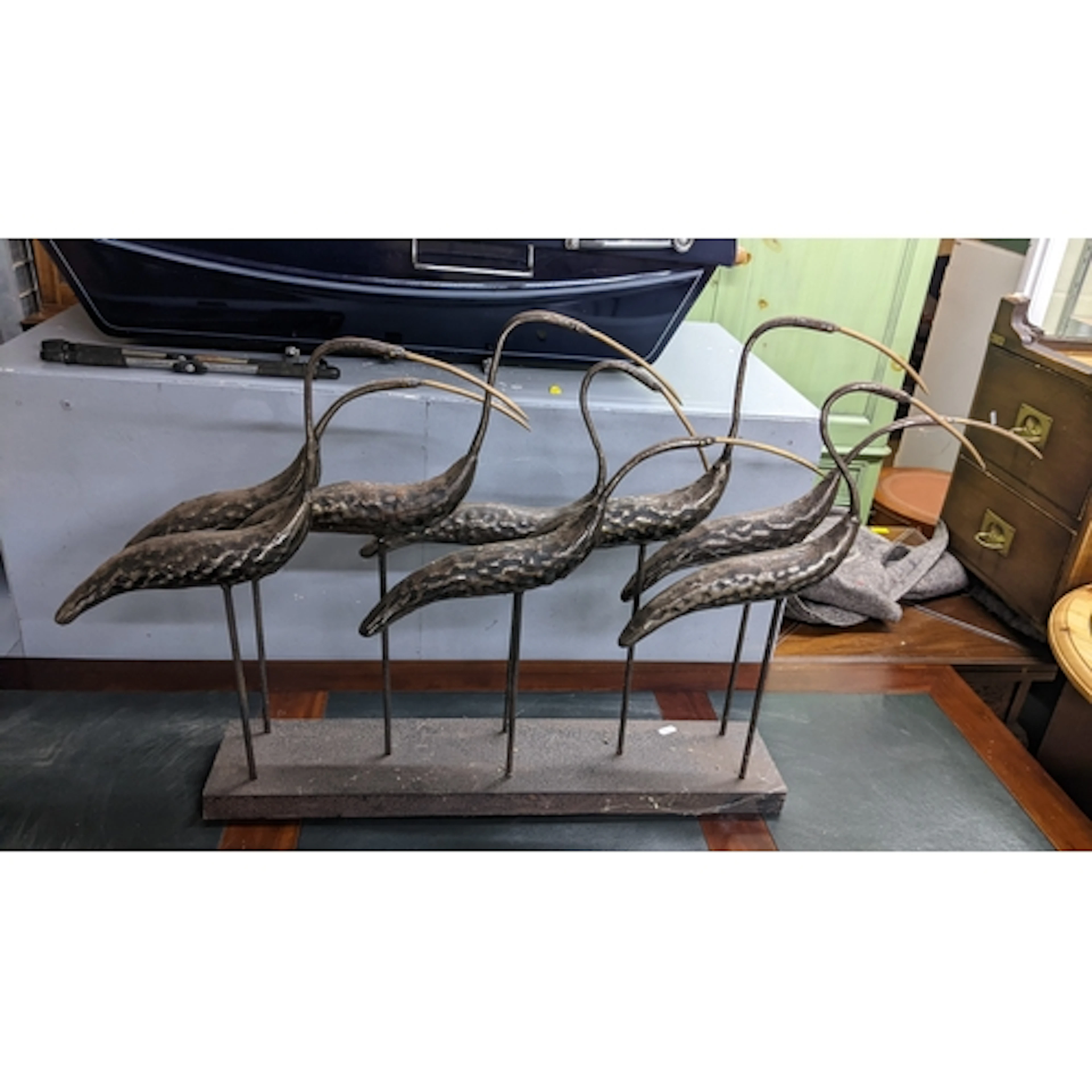 A vintage patinated metal bird sculpture in the form of a fl...