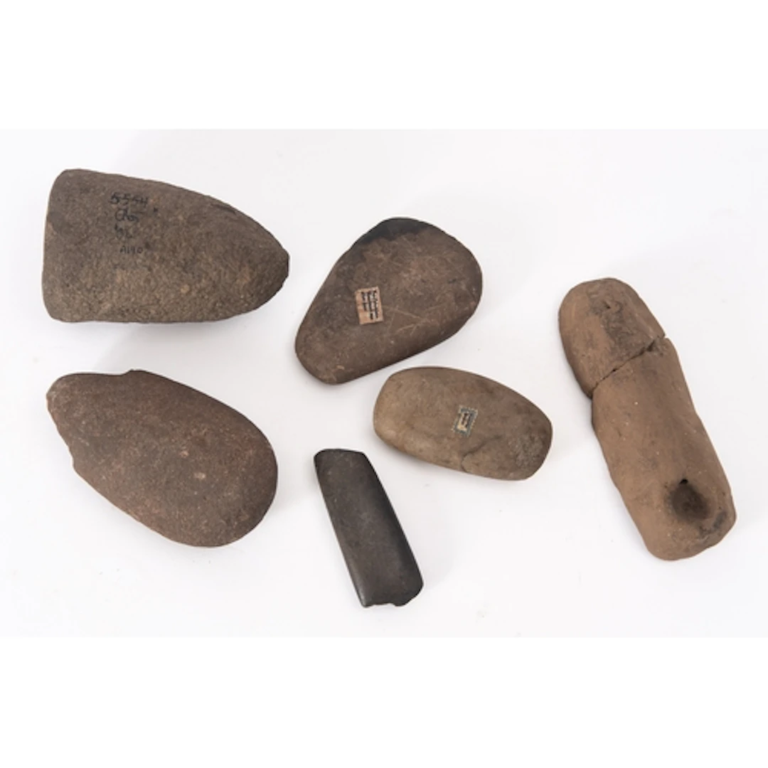 Four items of carved or shaped stone, each with labels sugge...