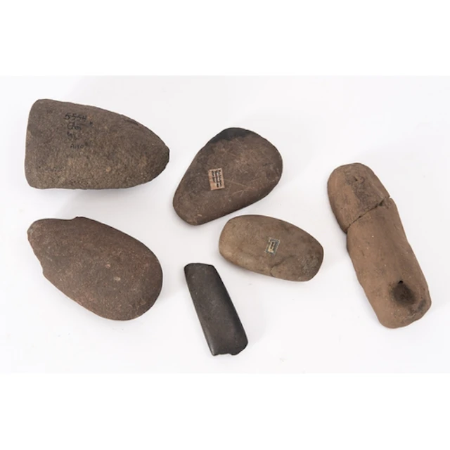 Four items of carved or shaped stone, each with labels sugge...