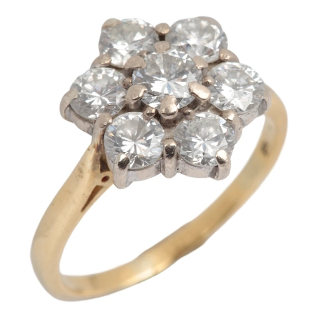 A diamond cluster ring, claw-set with seven brilliant-cut di...