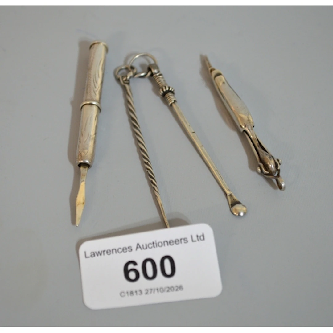 Group of three silver toothpicks and an earwax remover
