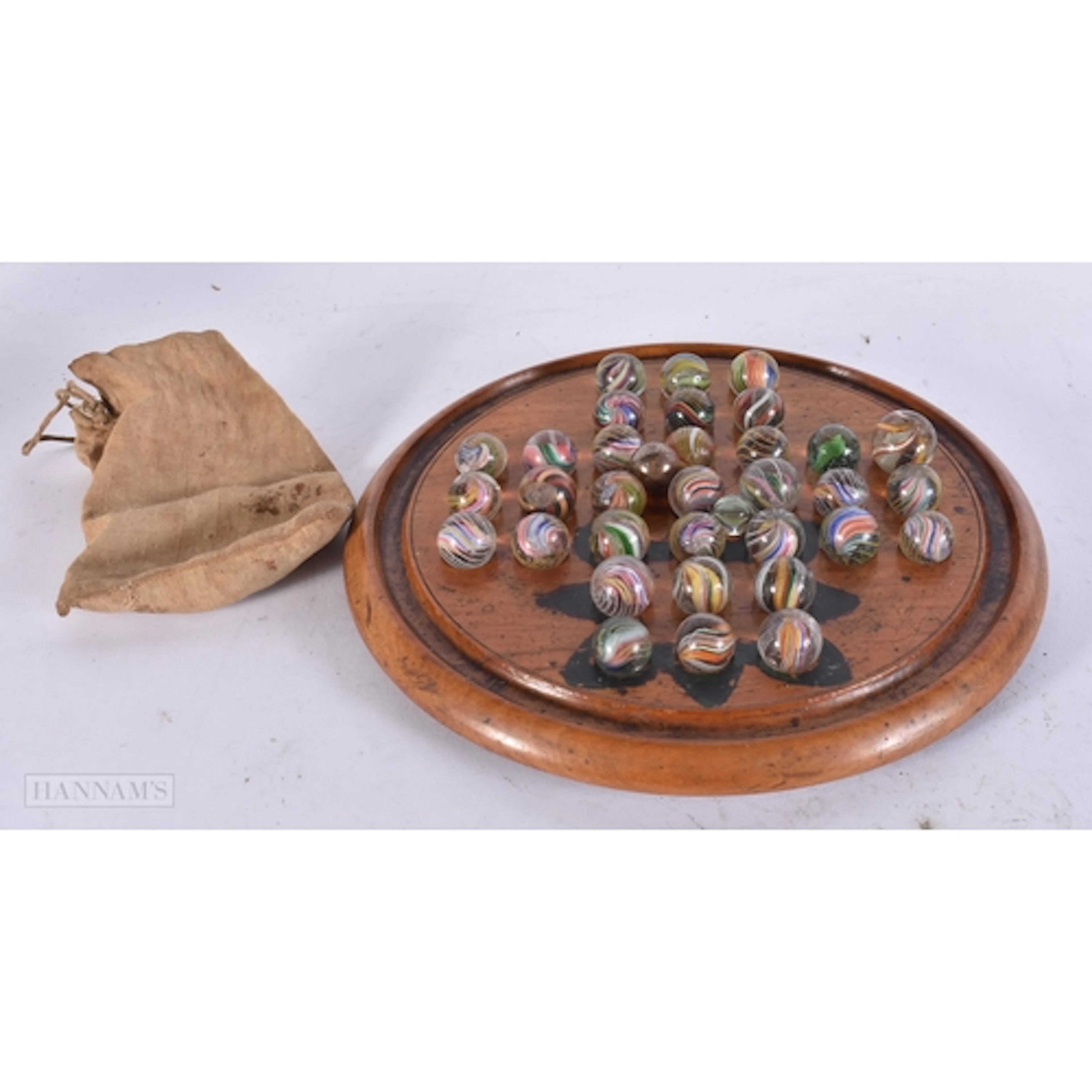 A SET OF ANTIQUE SOLITAIRE MARBLES ON STAND. 18.5 cm wide.