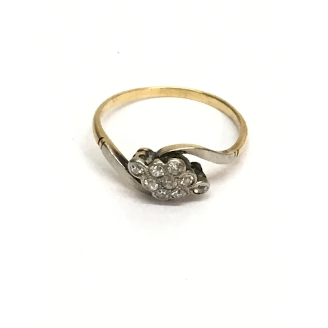 An unmarked gold ring set with white stones in twist setting...