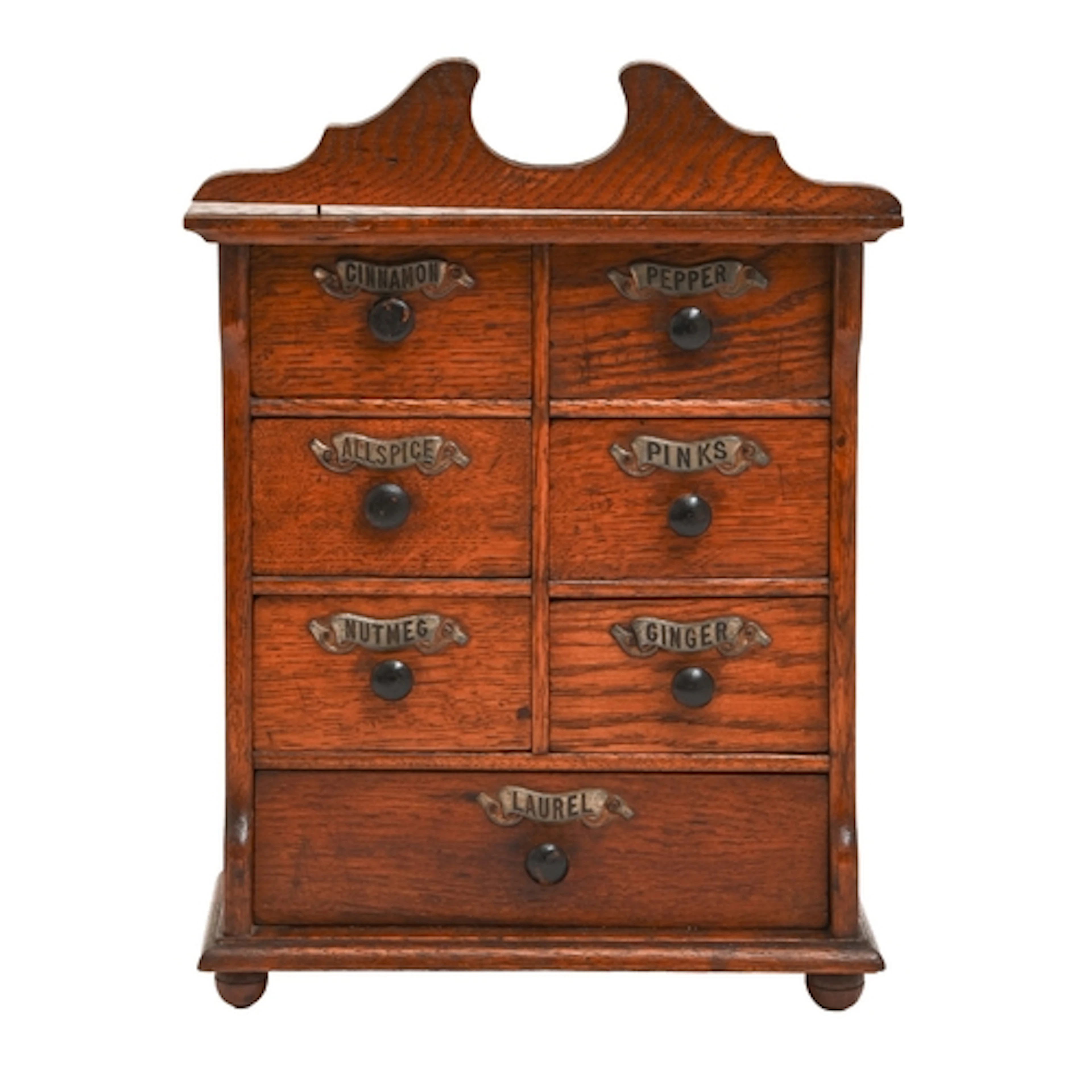 An oak spice cabinet, c1910, the seven drawers with stamped ...
