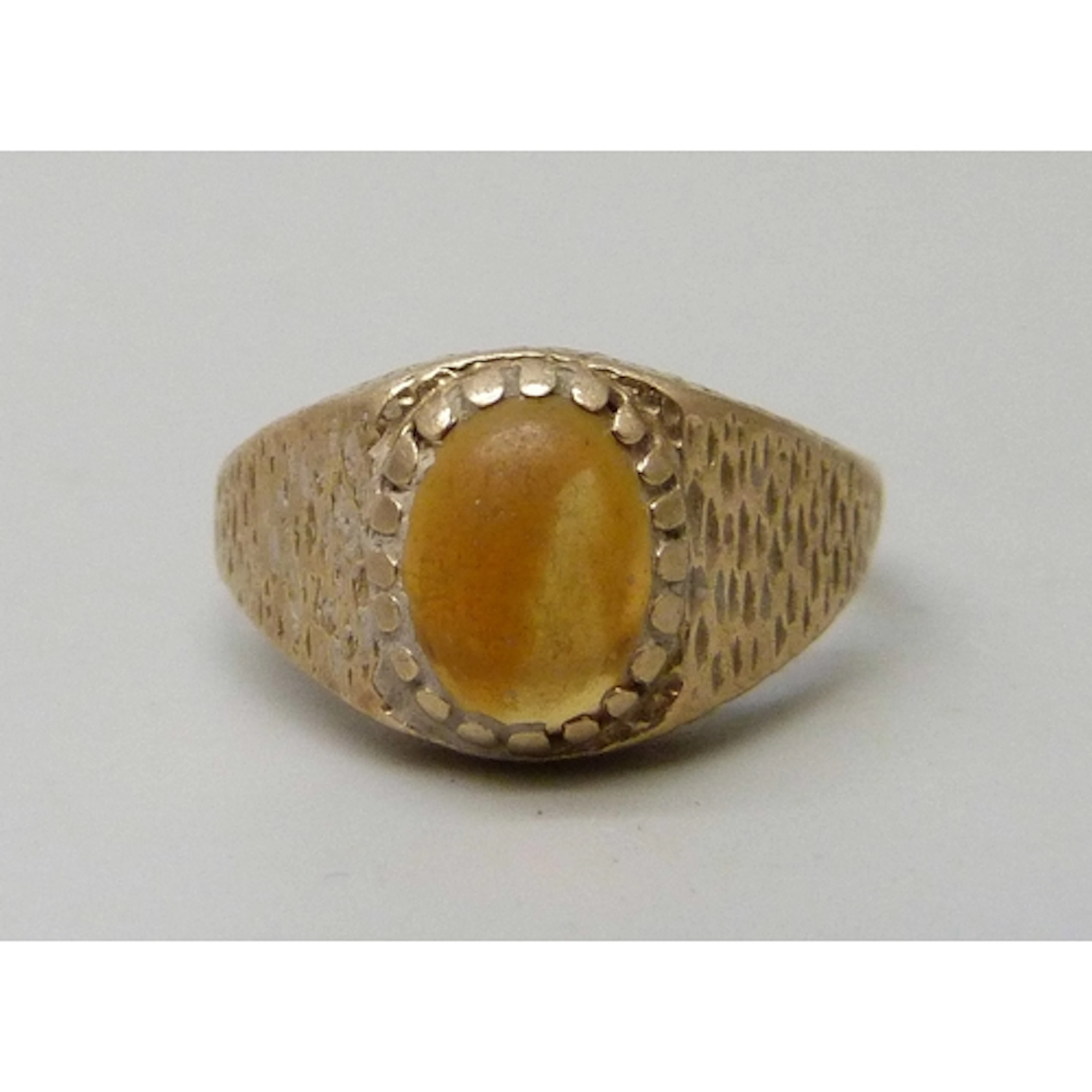 A 9ct gold and orange stone Brutalist style signet ring, 2.9...