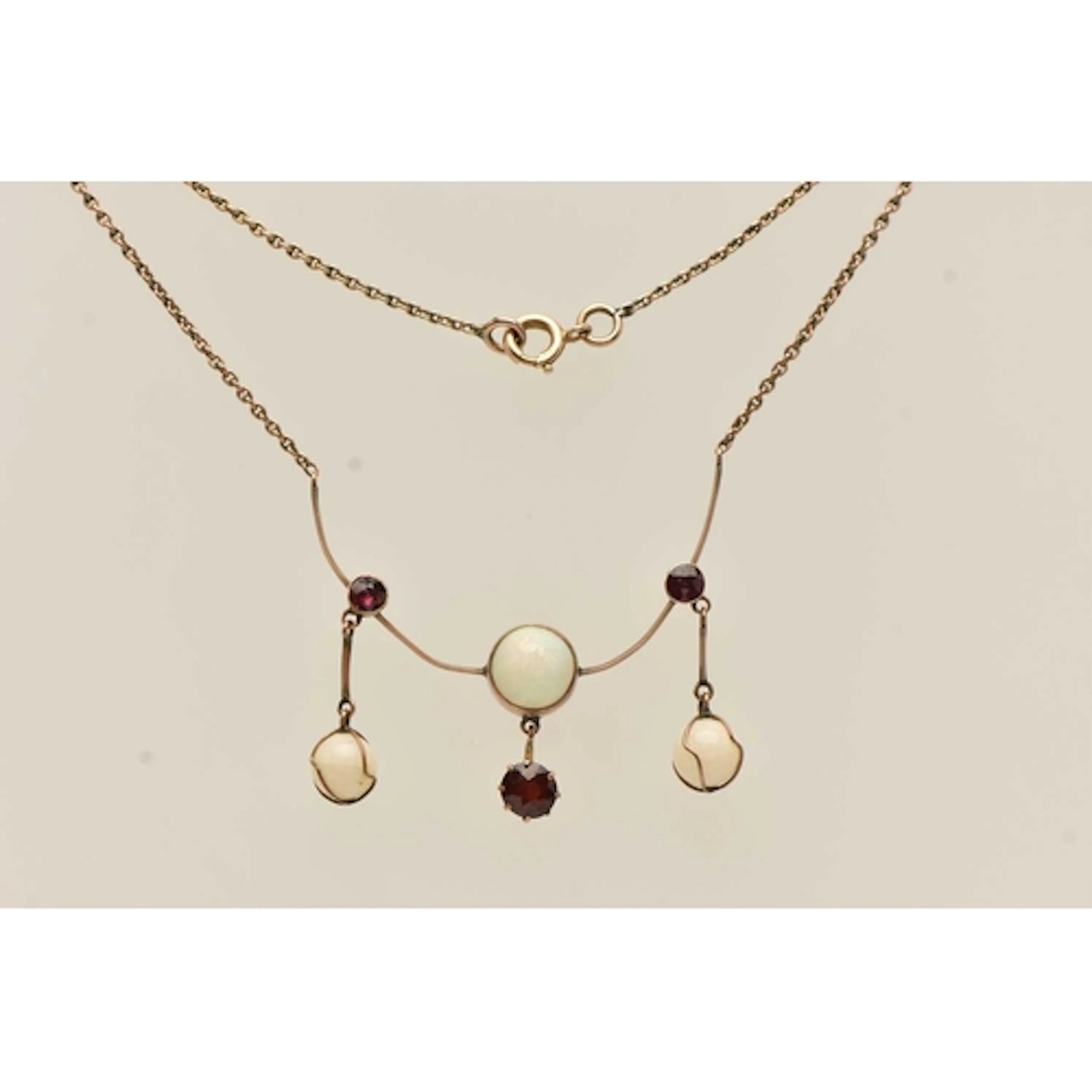 A YELLOW METAL OPAL AND GARNET PENDANT NECKLACE, the pendant...