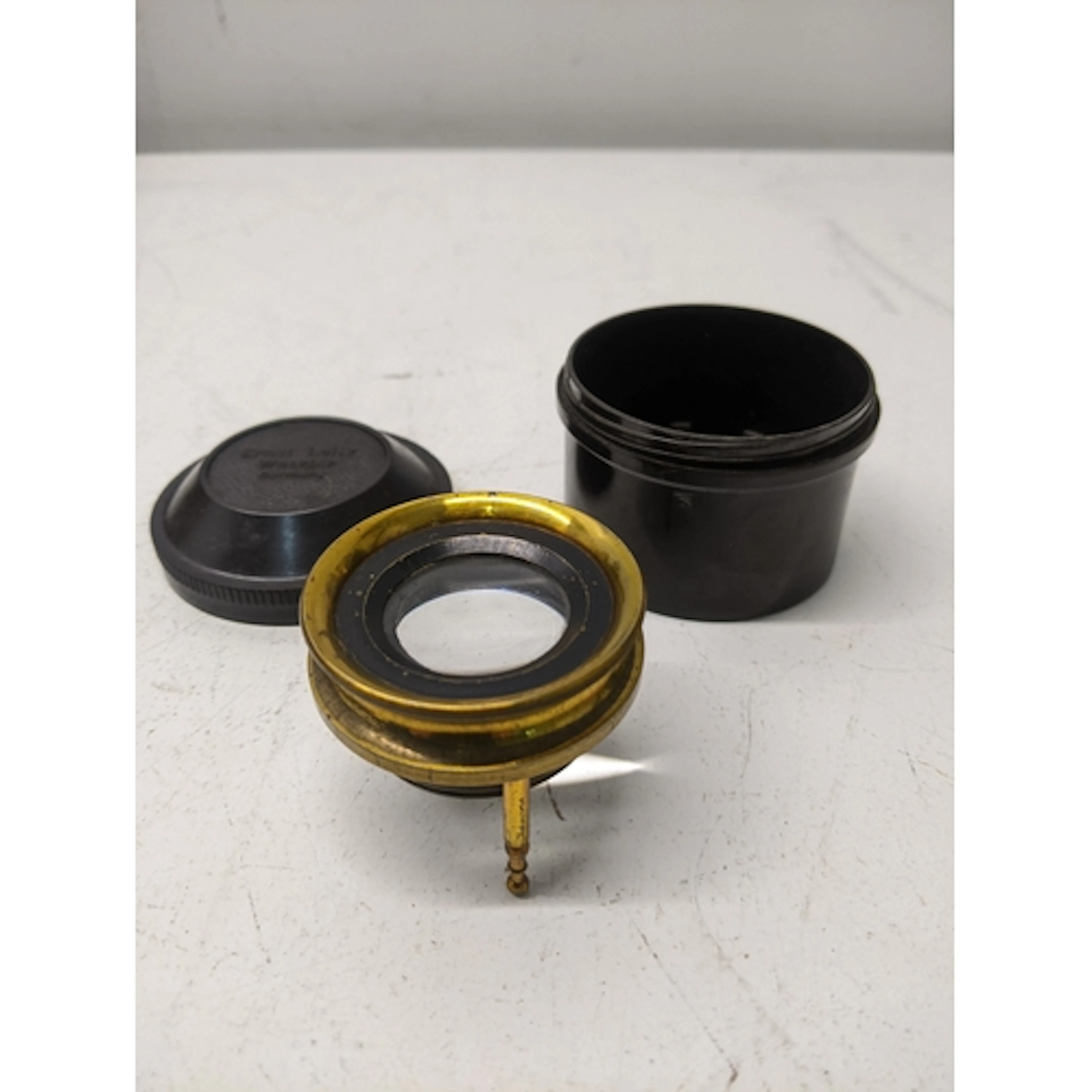 A gilt brass adjustable map reading lens on three tripod fee...
