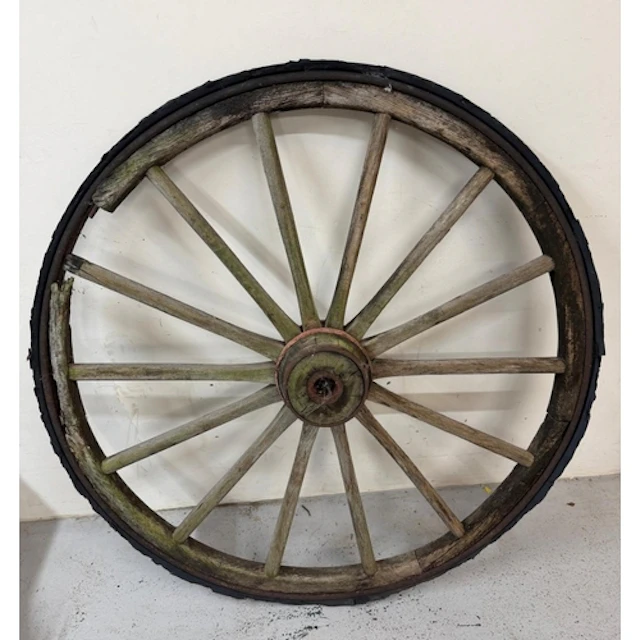 A wooden wagon wheel with metal rim band