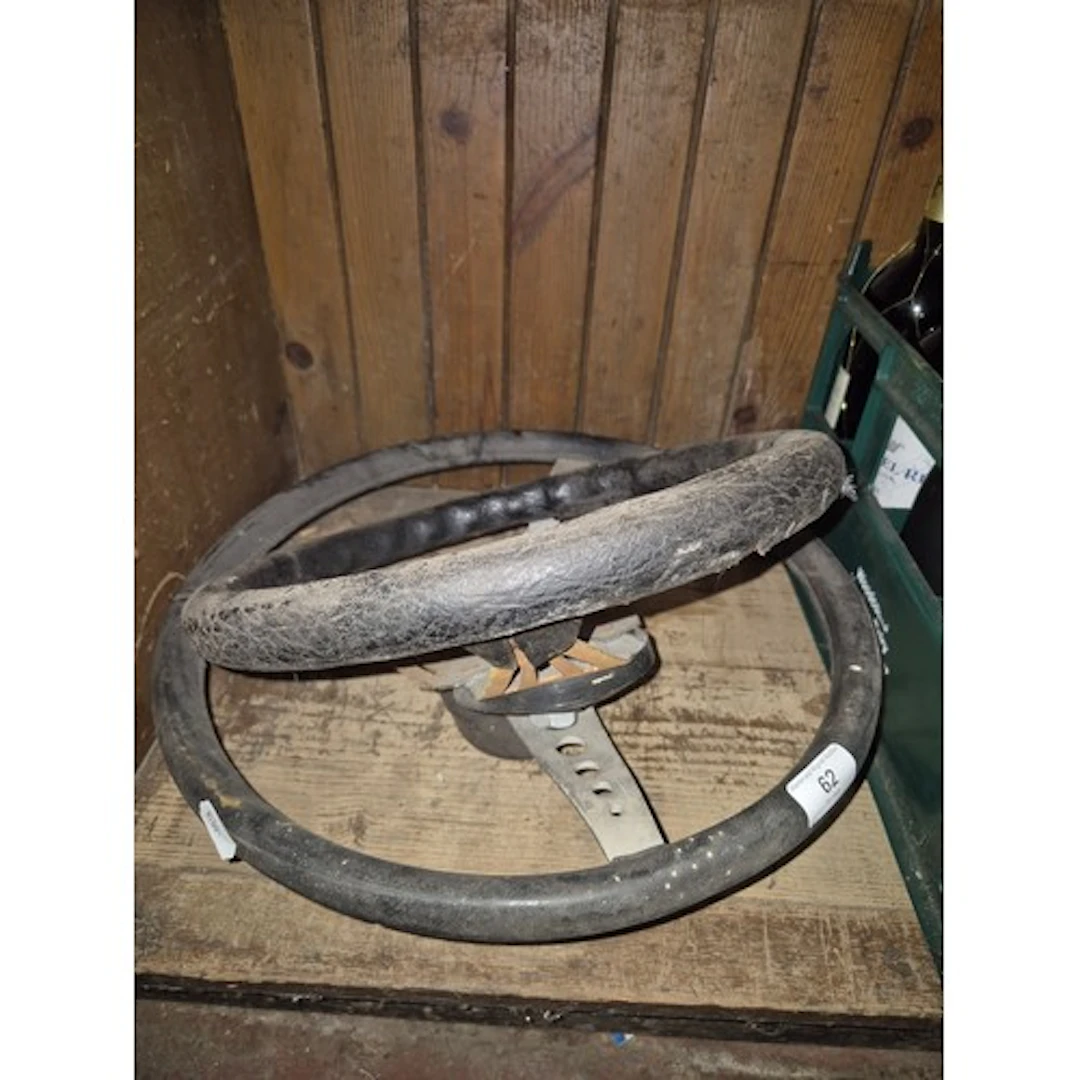2 car steering wheels, one sports type, one possibly 1960s m...