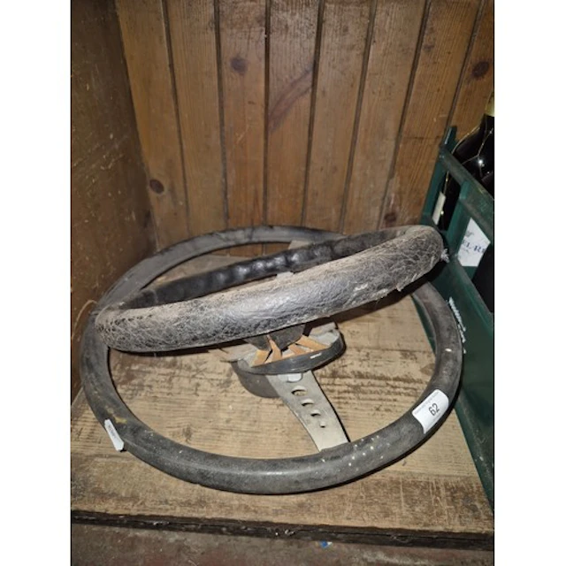 2 car steering wheels, one sports type, one possibly 1960s m...