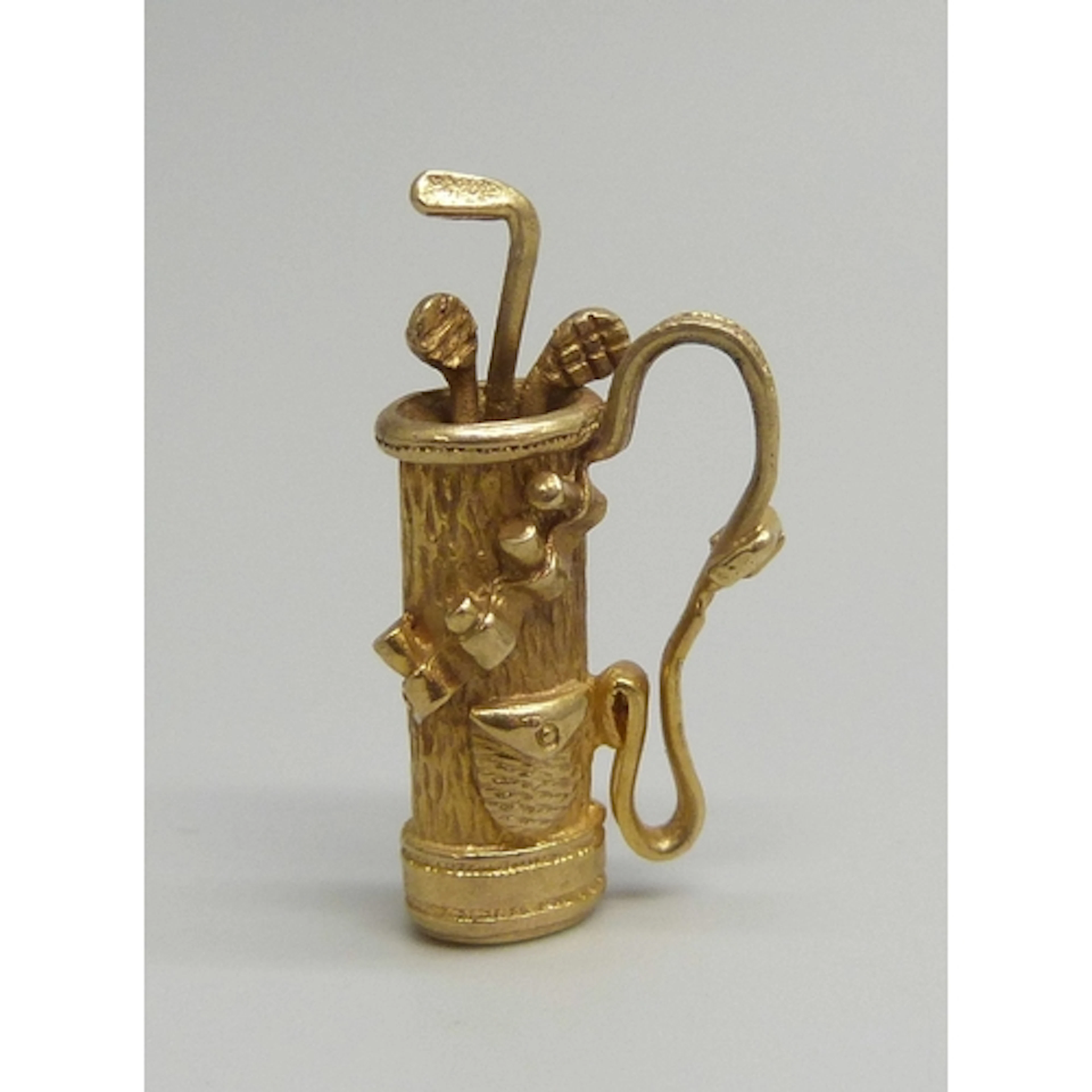 A 9ct gold charm or pendant in the form of a bag of golf clu...