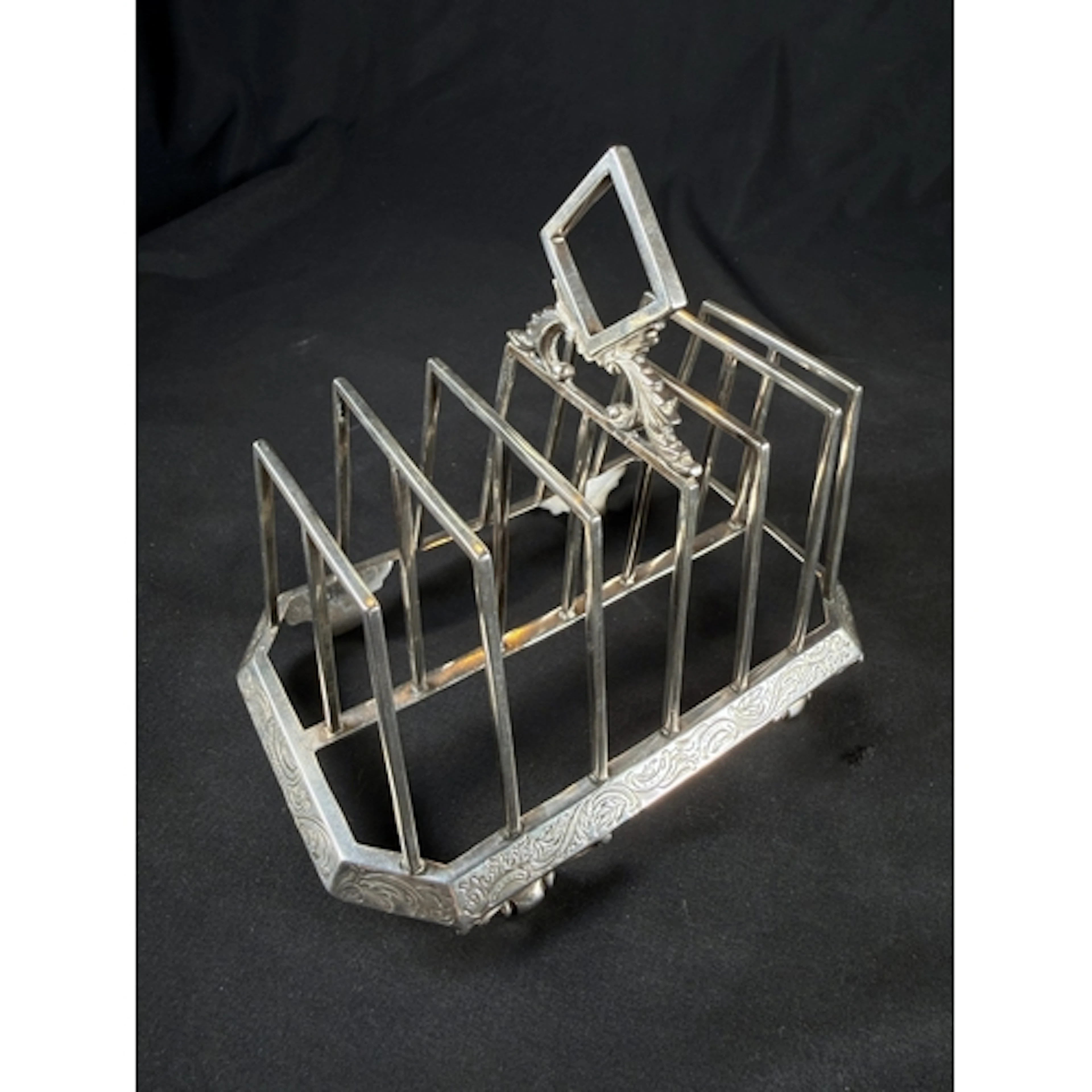 A Victorian hallmarked silver 6 spaced toast rack with etche...
