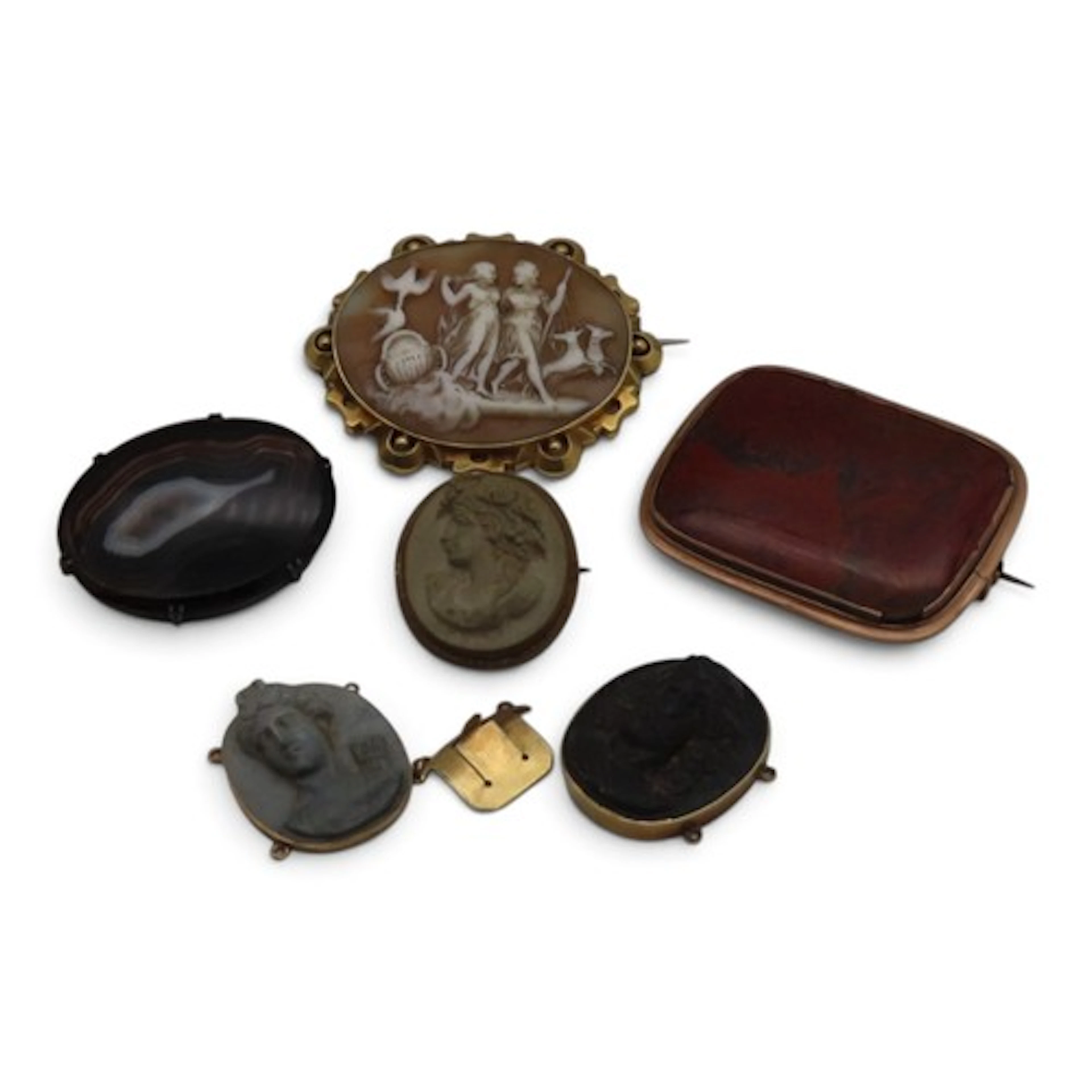 A collection of four brooches, to include a carved shell cam...