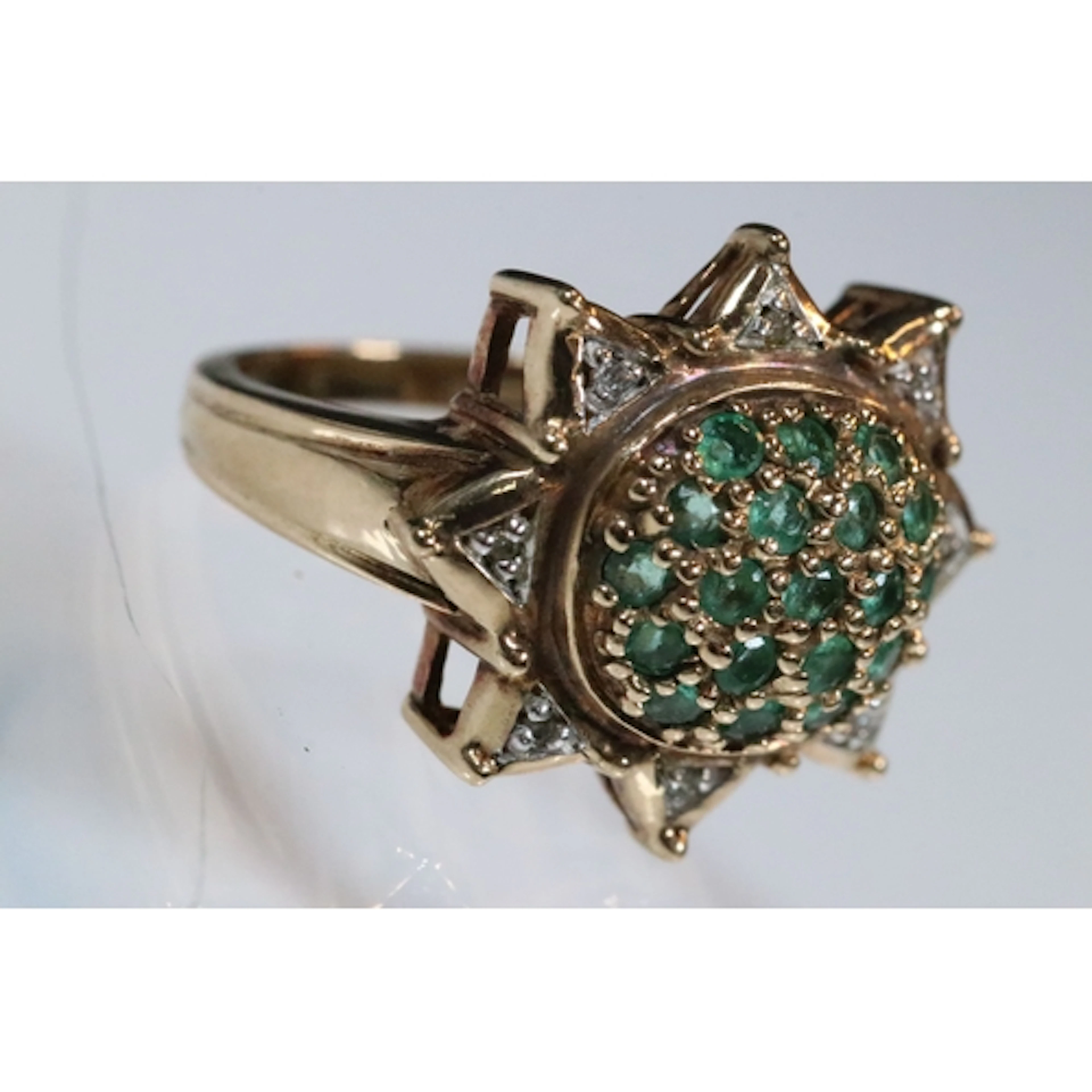 9ct gold, emerald and diamond ring. The ring having an oval ...