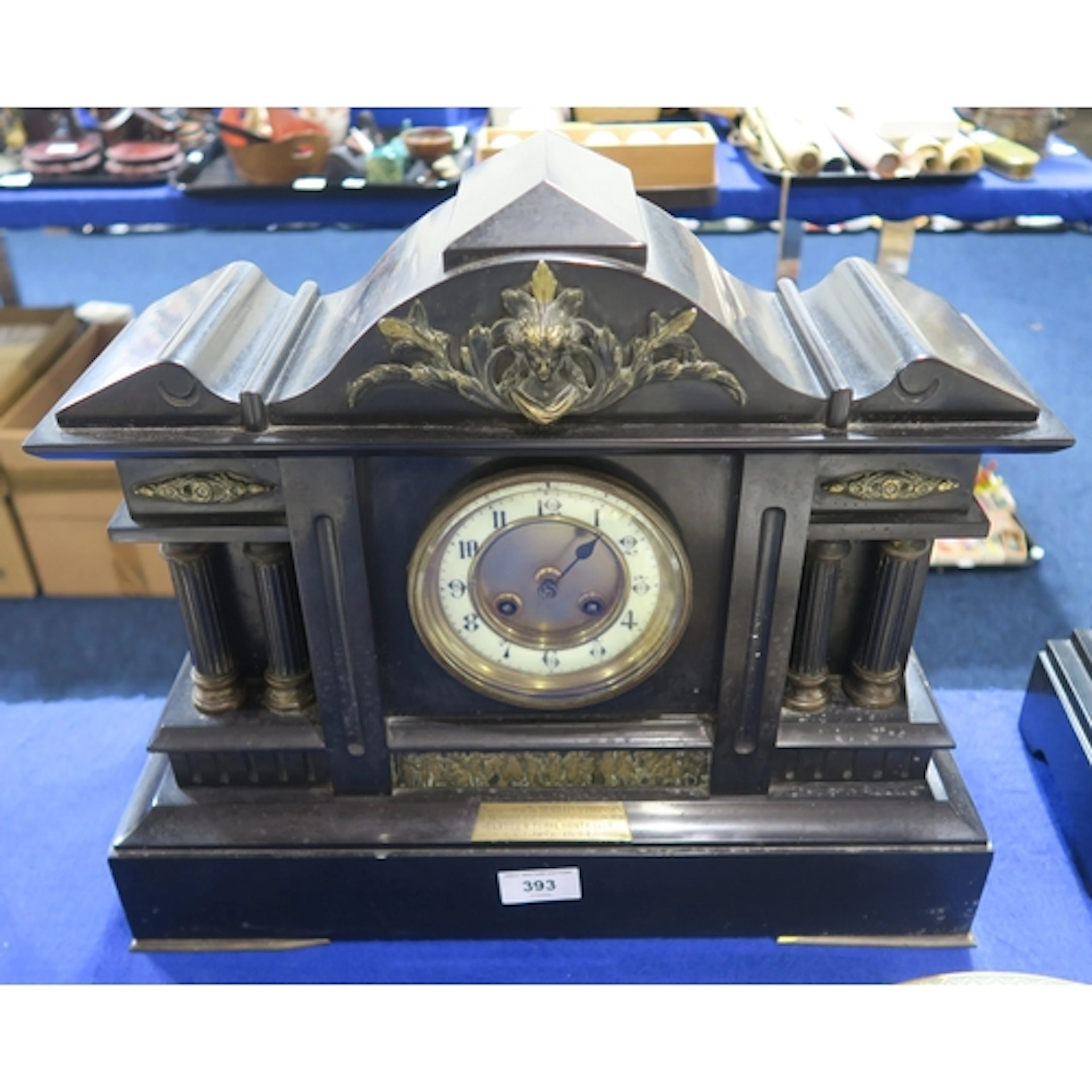 A black slate mantle clock with four columns to the front