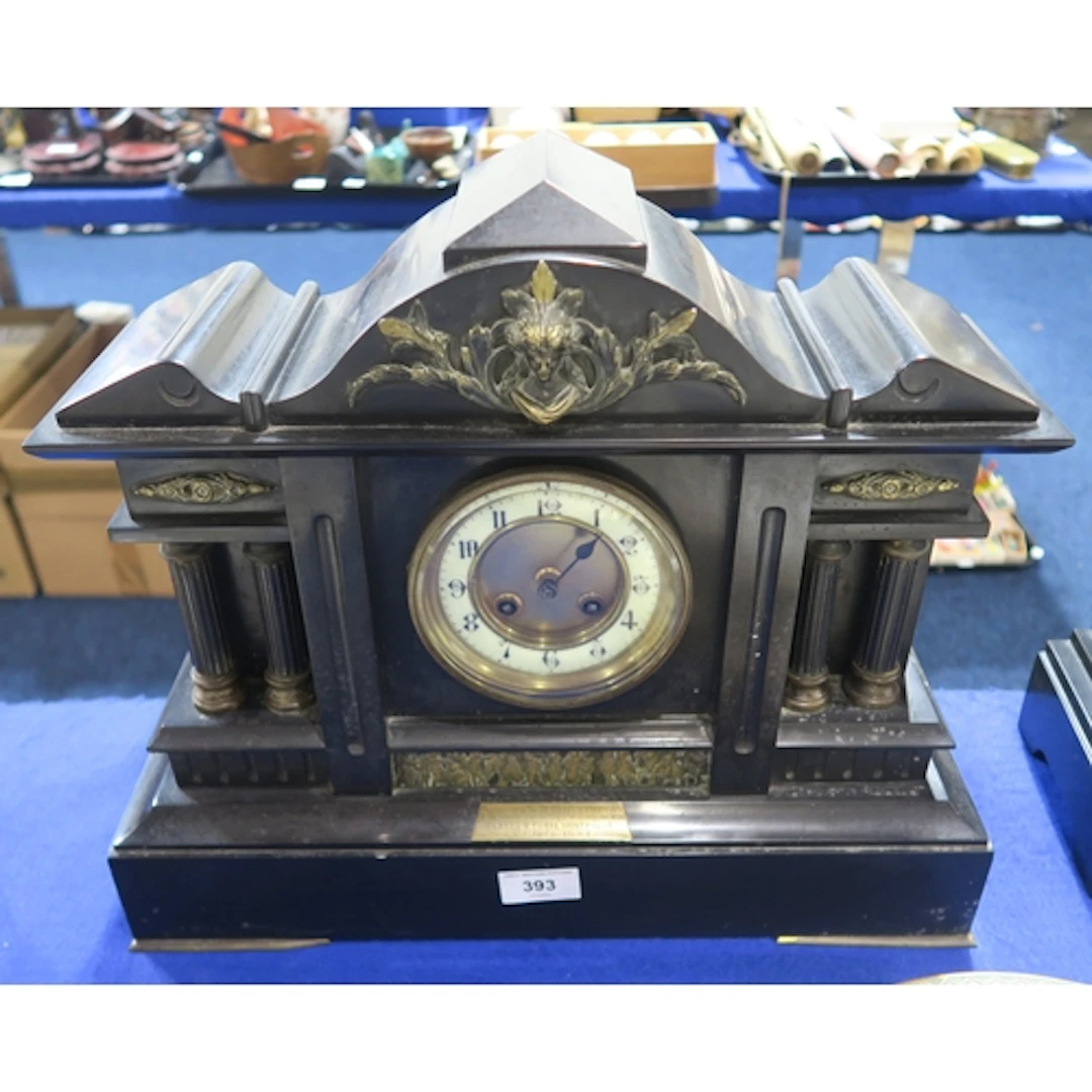 A black slate mantle clock with four columns to the front