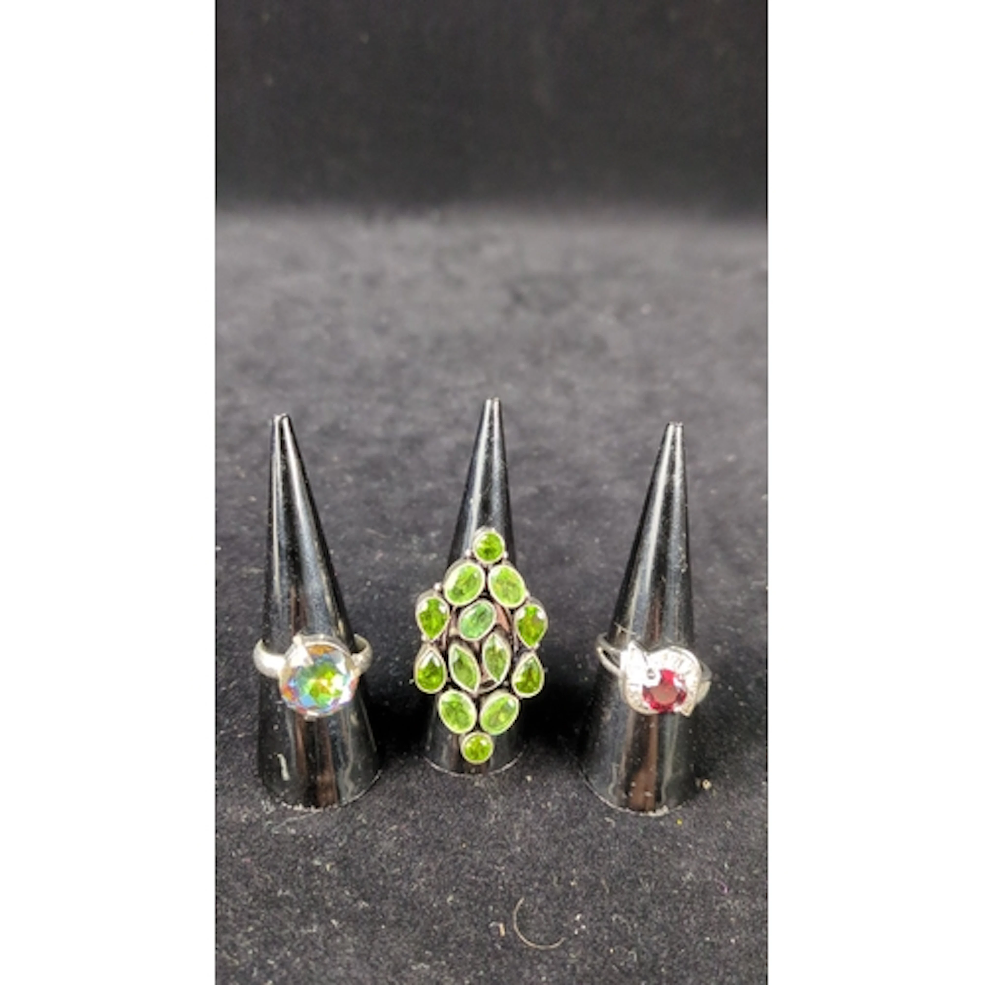 Three silver dress rings: one claw-set with an iridescent ro...
