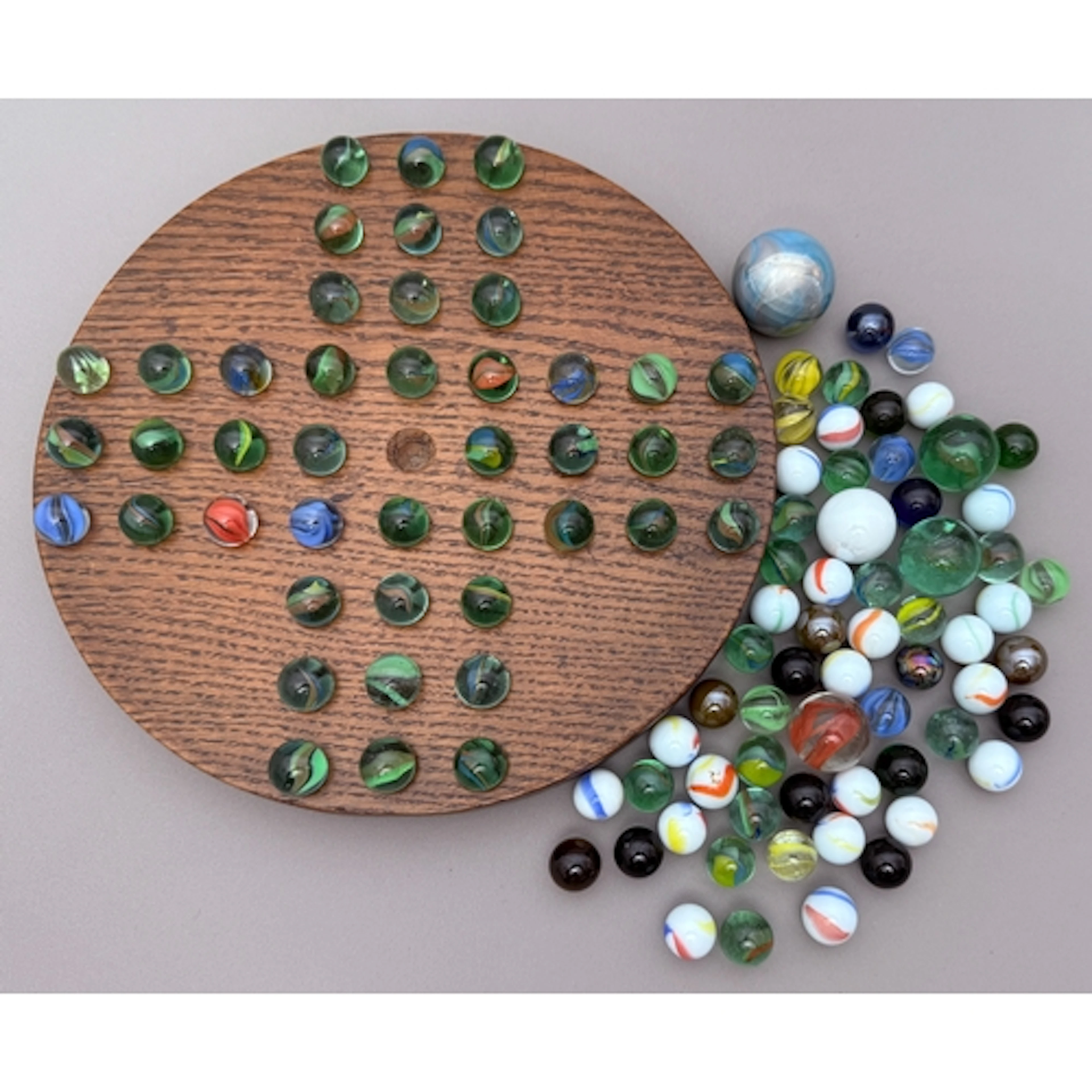 A hand made turned oak solitaire board with marbles - 23.5cm...