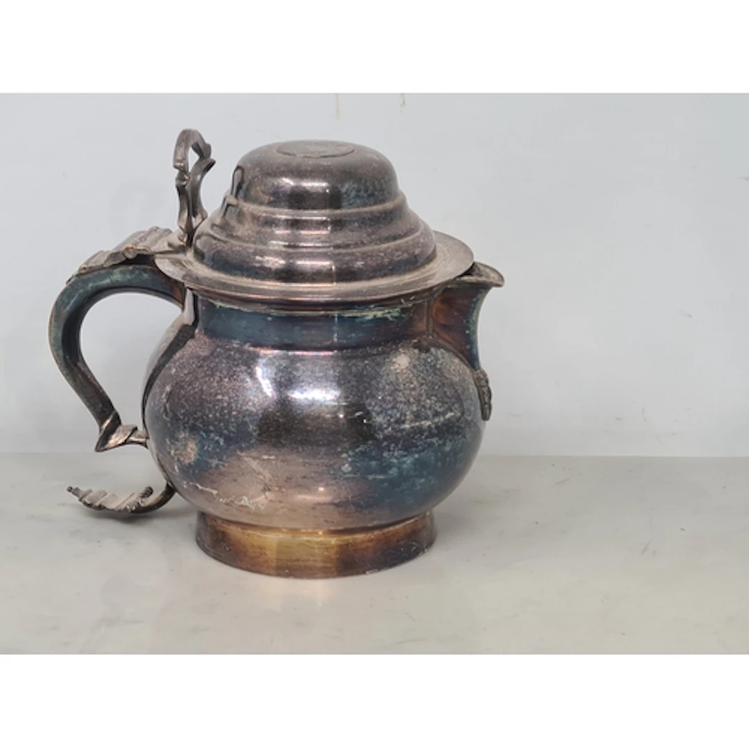 A Sheffield plated Ale Jug with domed lid inset coin bearing...