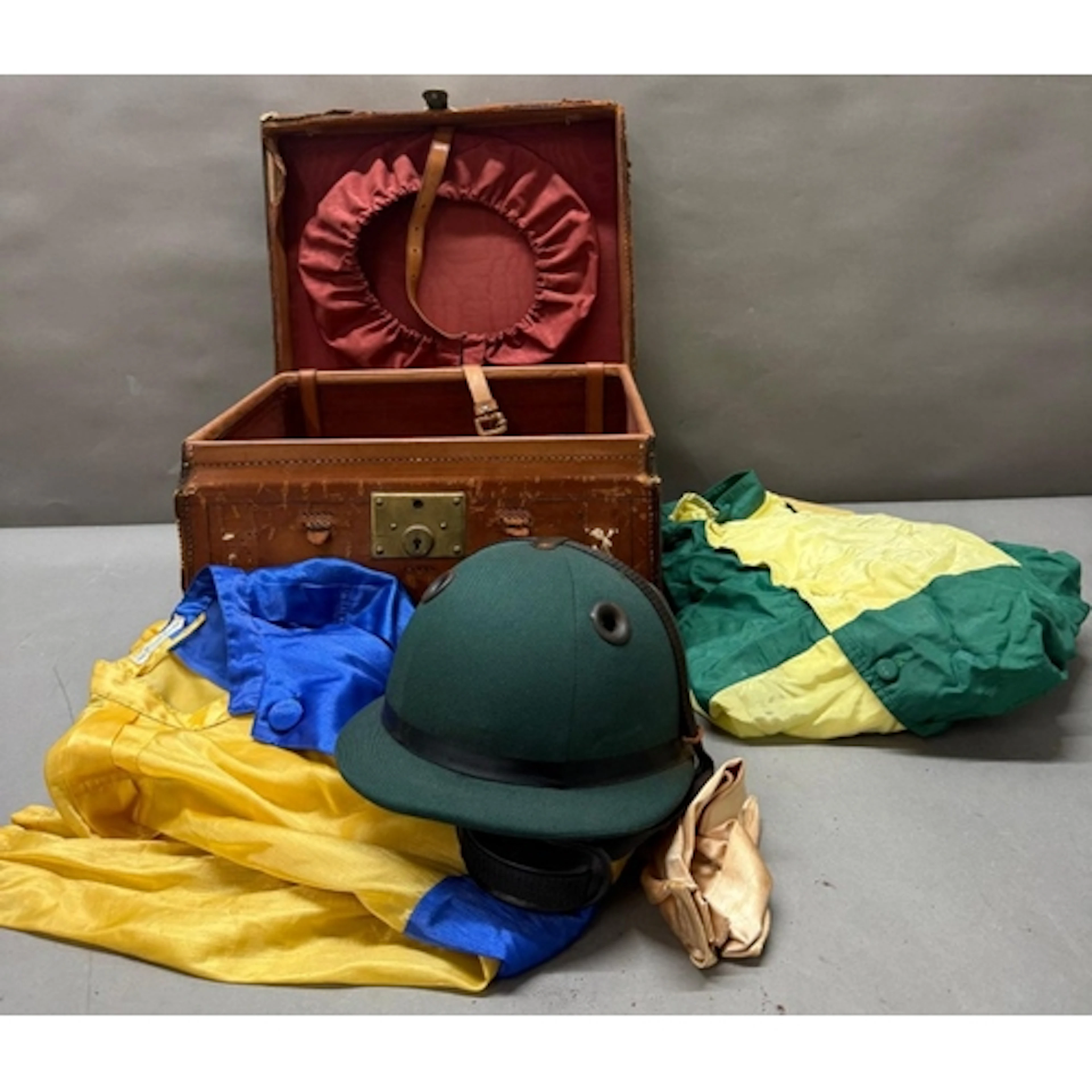 A vintage Jockeys case with silks and a polo players helmet....