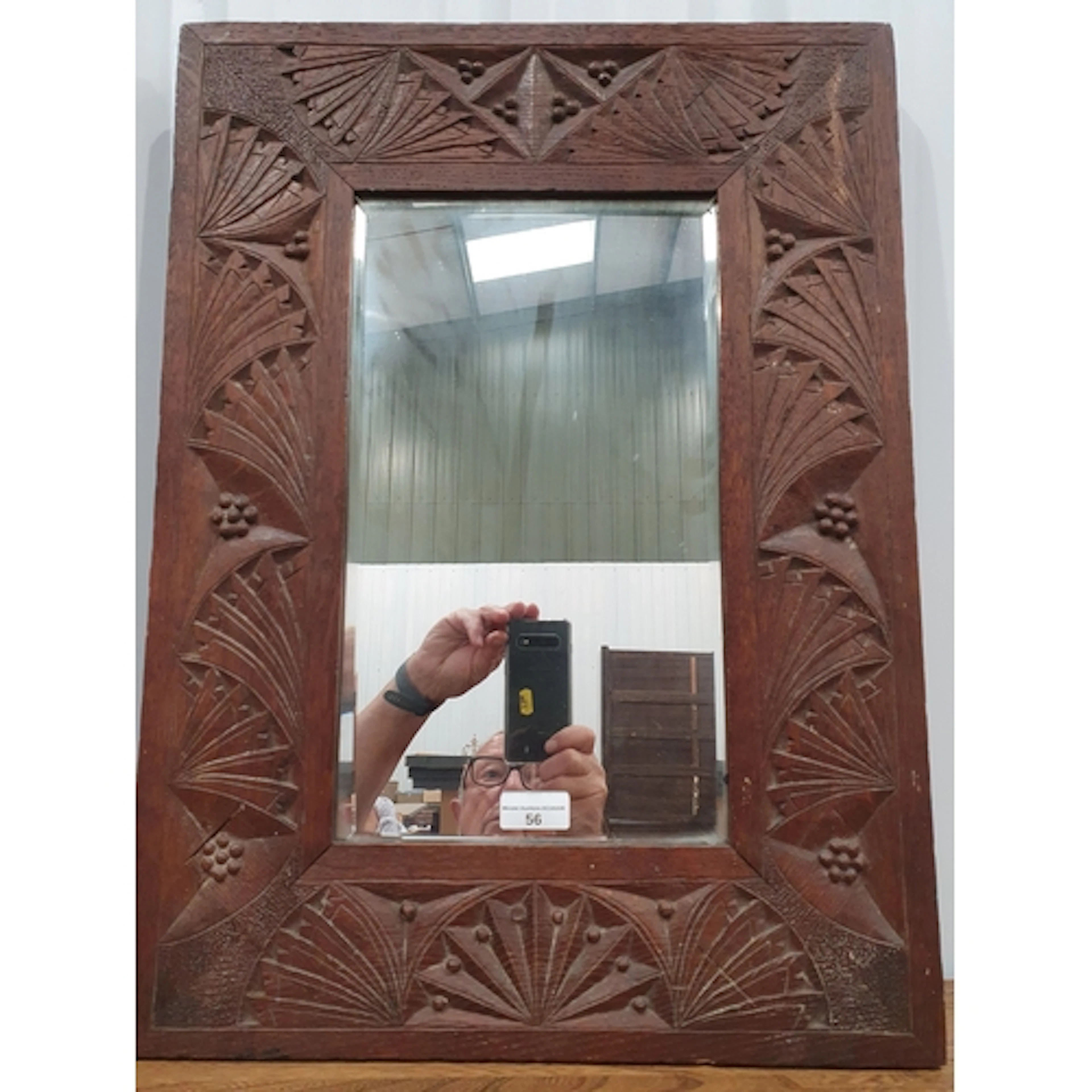A carved oak framed Wall Mirror with bevelled plate and styl...