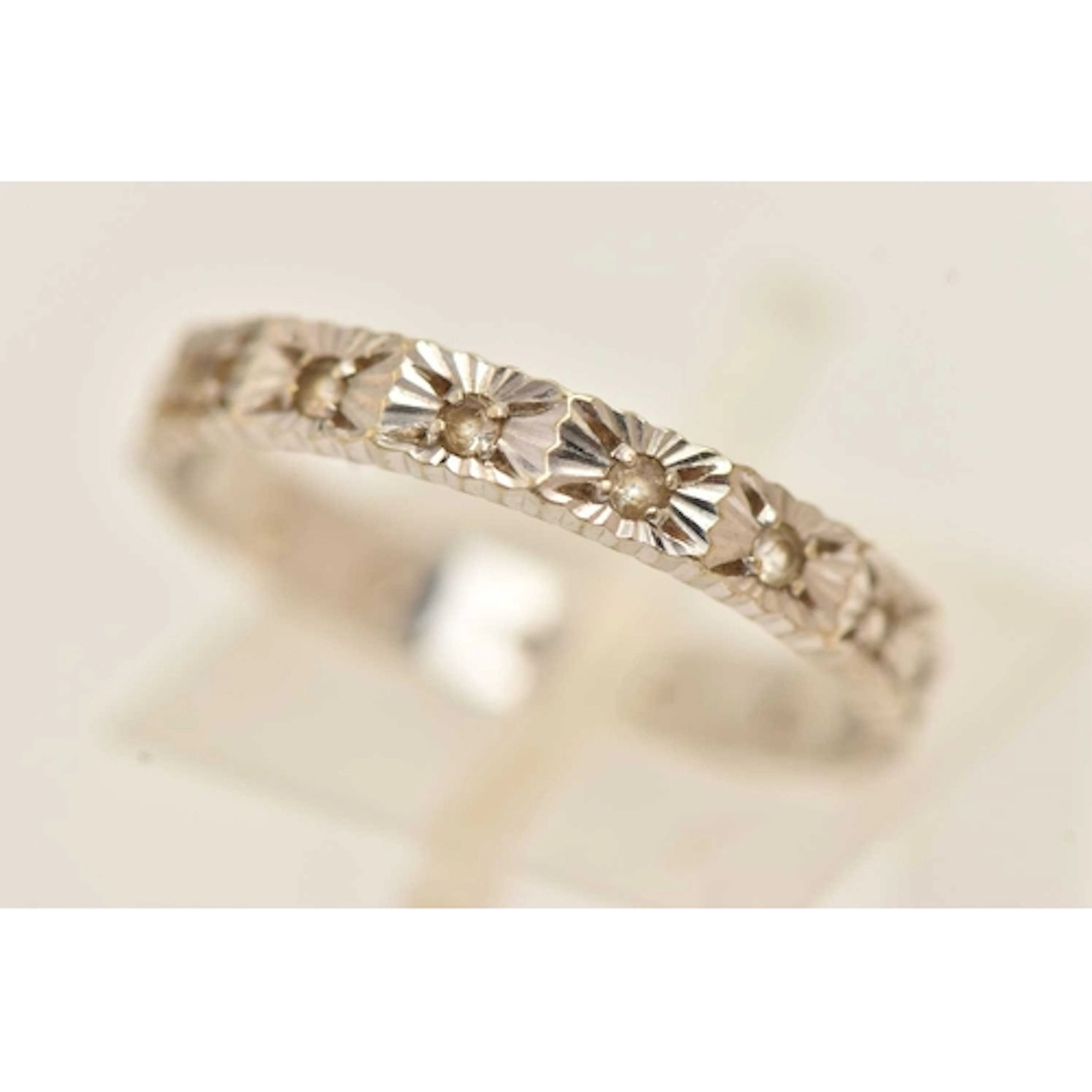 A WHITE METAL STONE SET FULL ETERNITY RING, a textured band ...