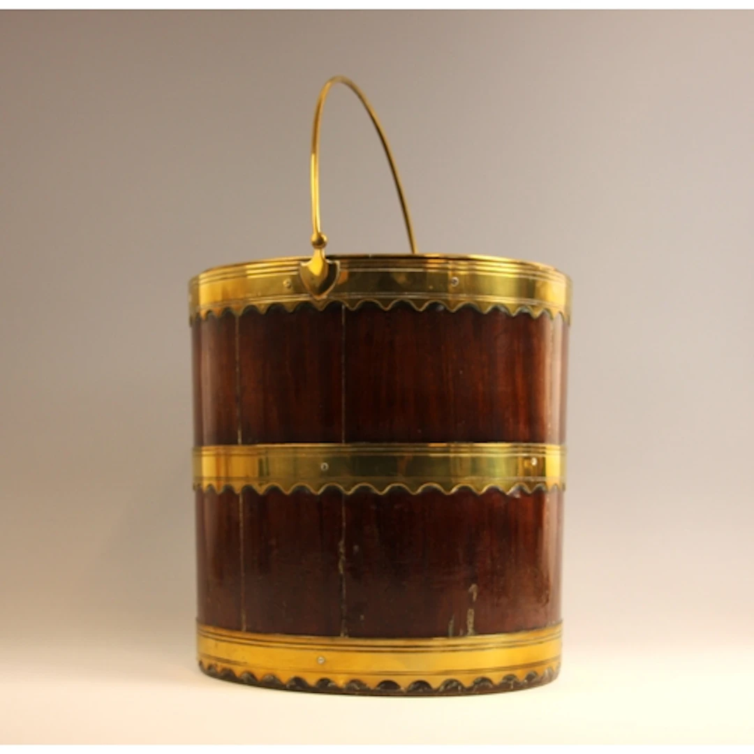 A George III mahogany and brass coopered coal bucket, the ov...
