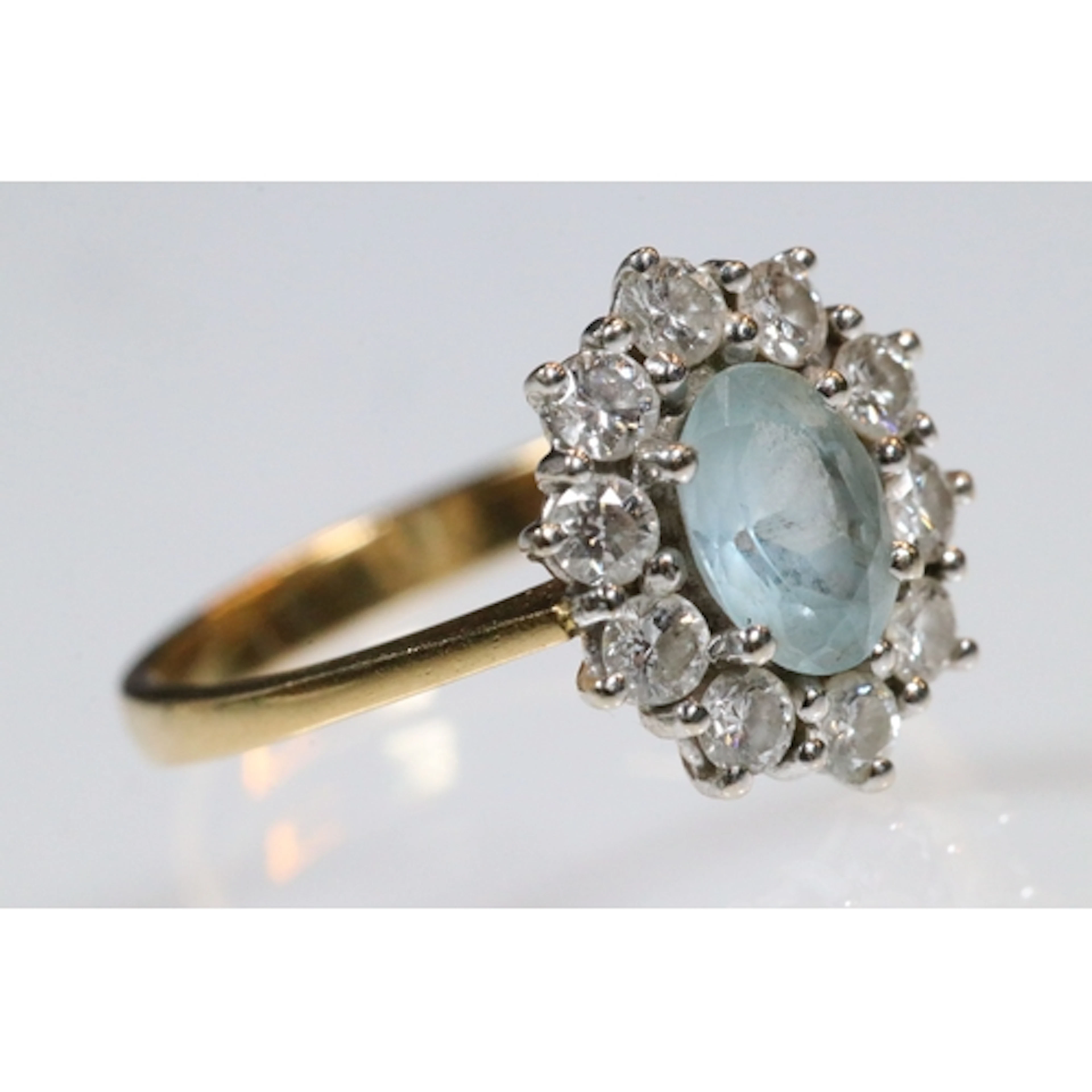 18ct gold aquamarine and diamond halo ring. The ring being s...