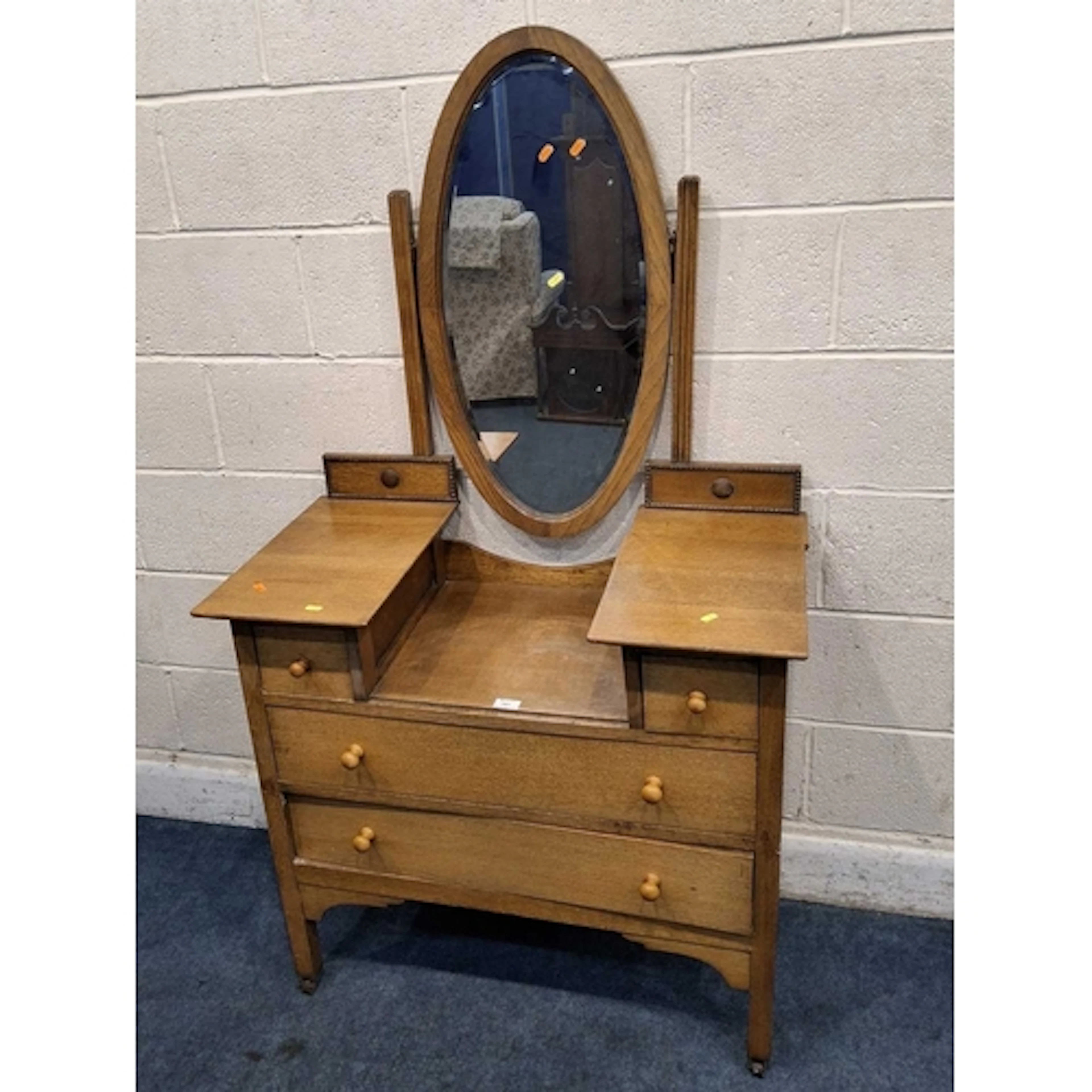 AN EARLY 20TH CENTURY OAK DRESSING TABLE, with an oval bevel...