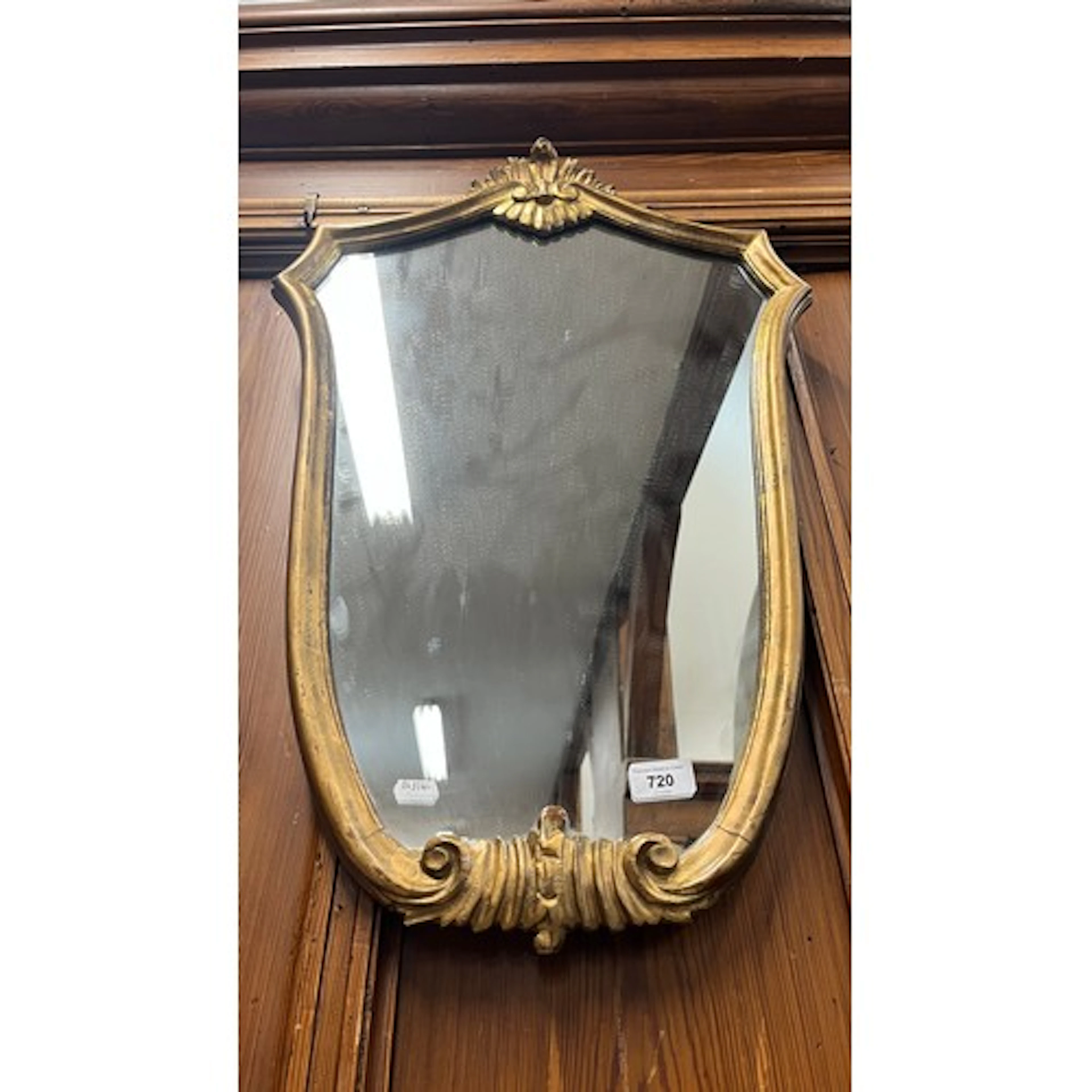 Gilt wall mirror with scroll design.