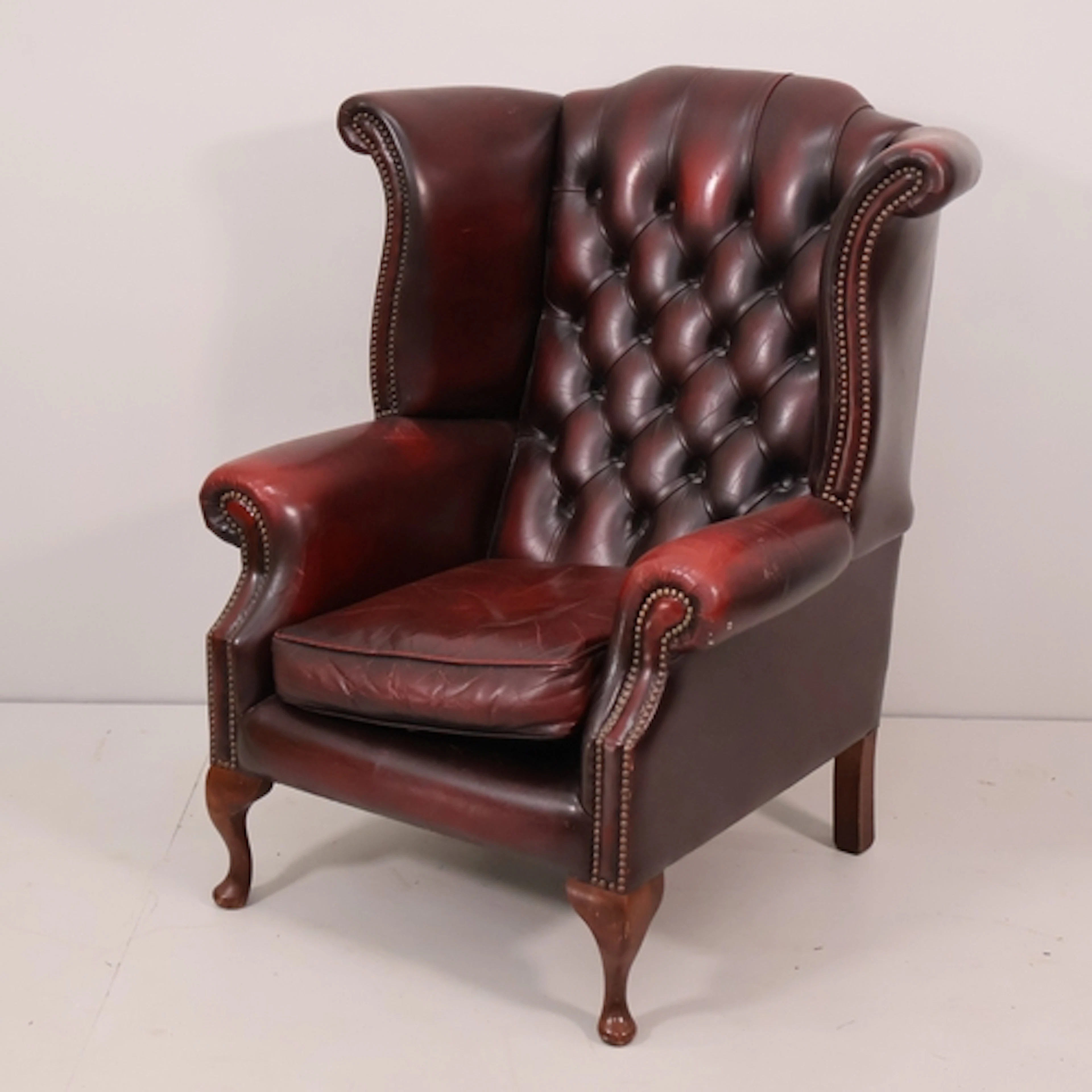 A oxblood leather upholstered Chesterfield style wingback fi...