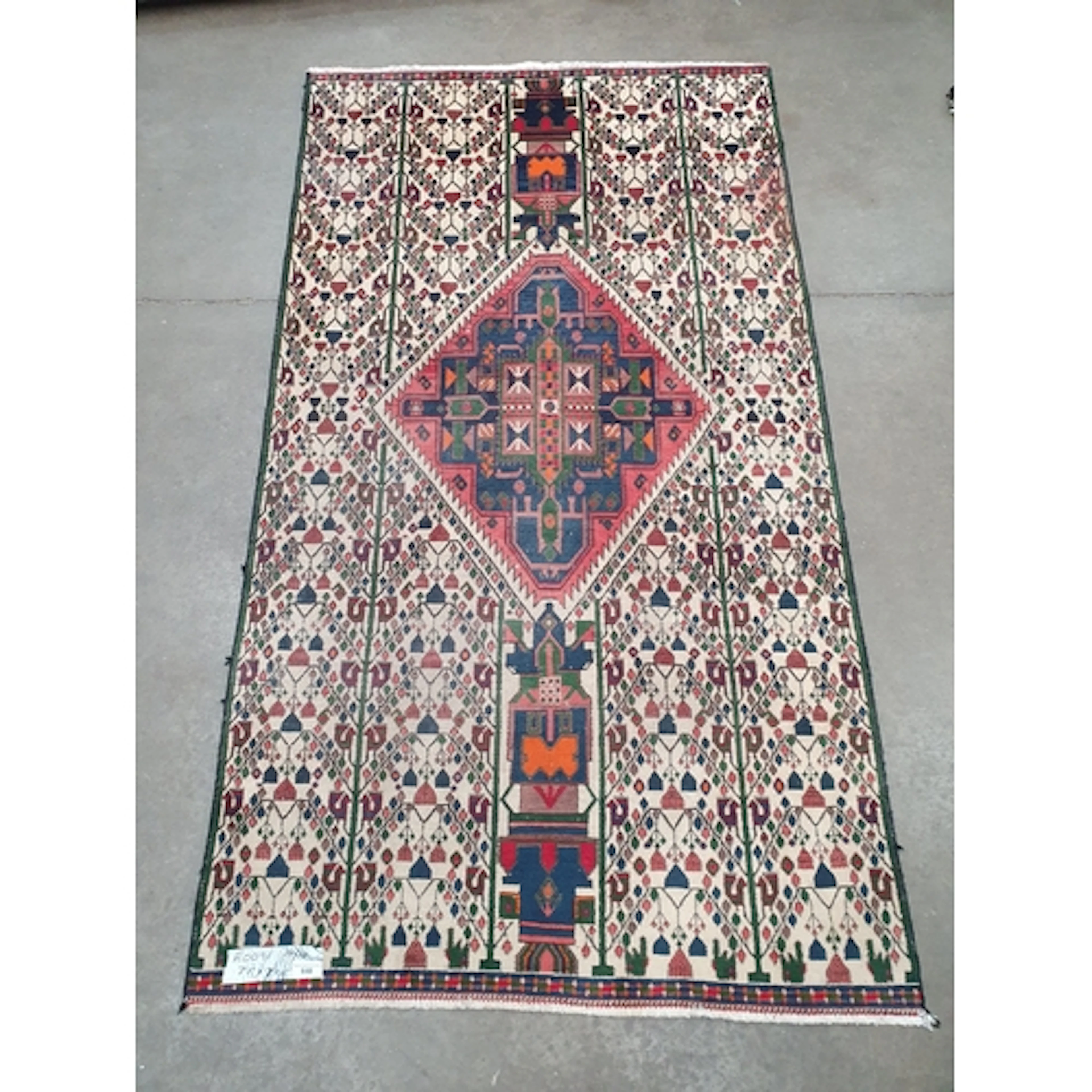 A beige ground rug, with large central lozenge in blue and r...