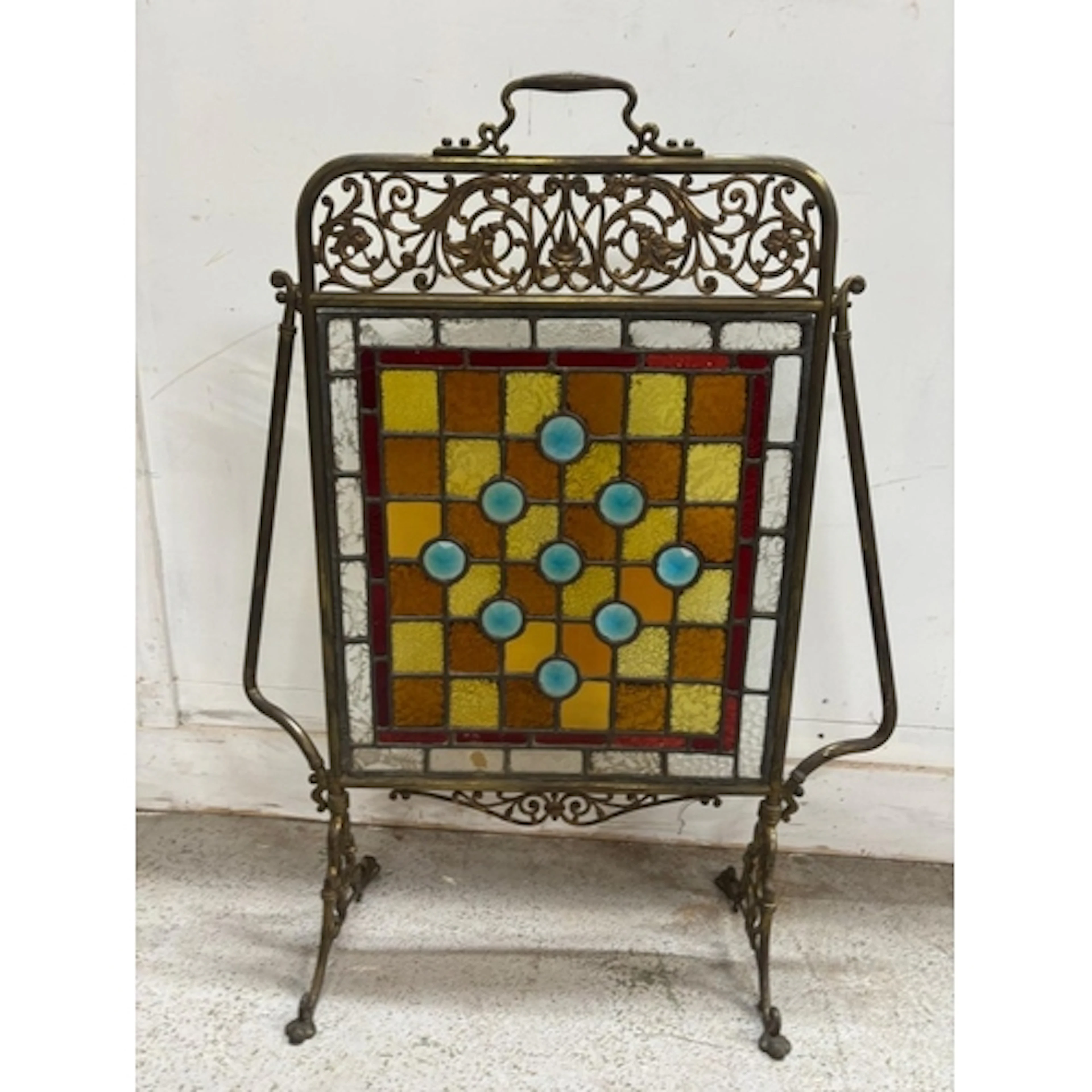 A vintage brass fireplace screen featuring a striking geomet...