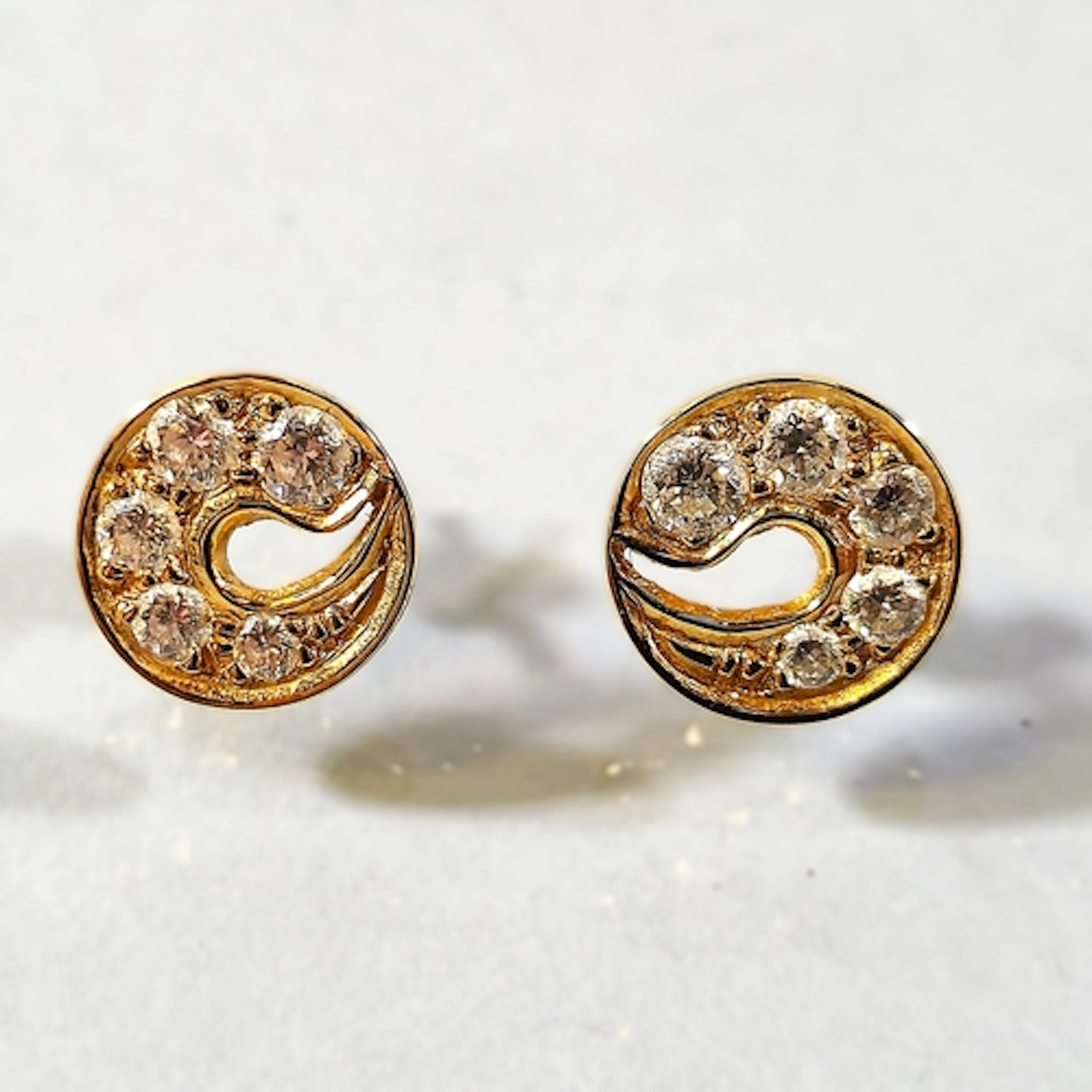 Pair of 14kt gold and diamond earrings, of disc form and set...
