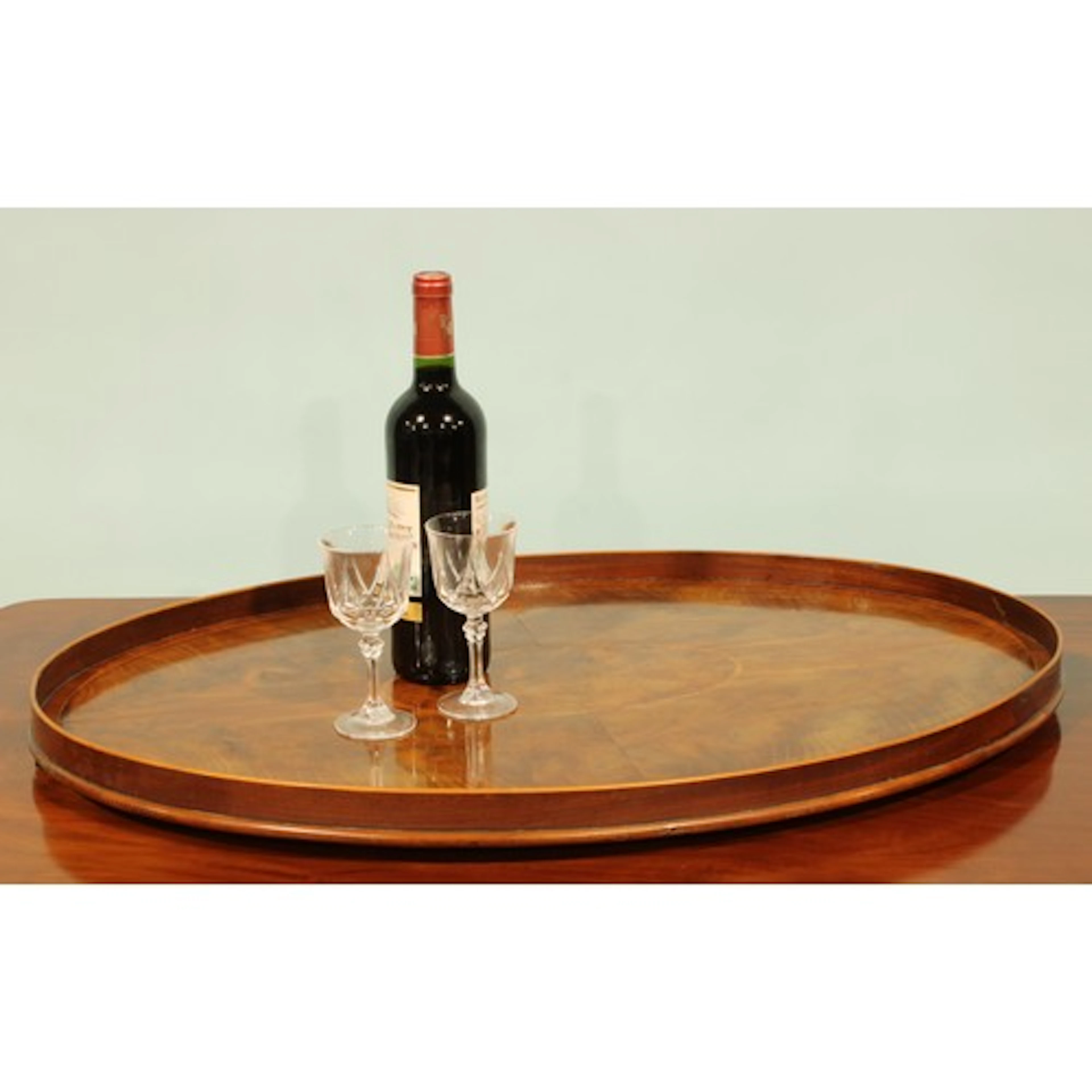 An Edwardian tulipwood crossbanded flame mahogany oval servi...