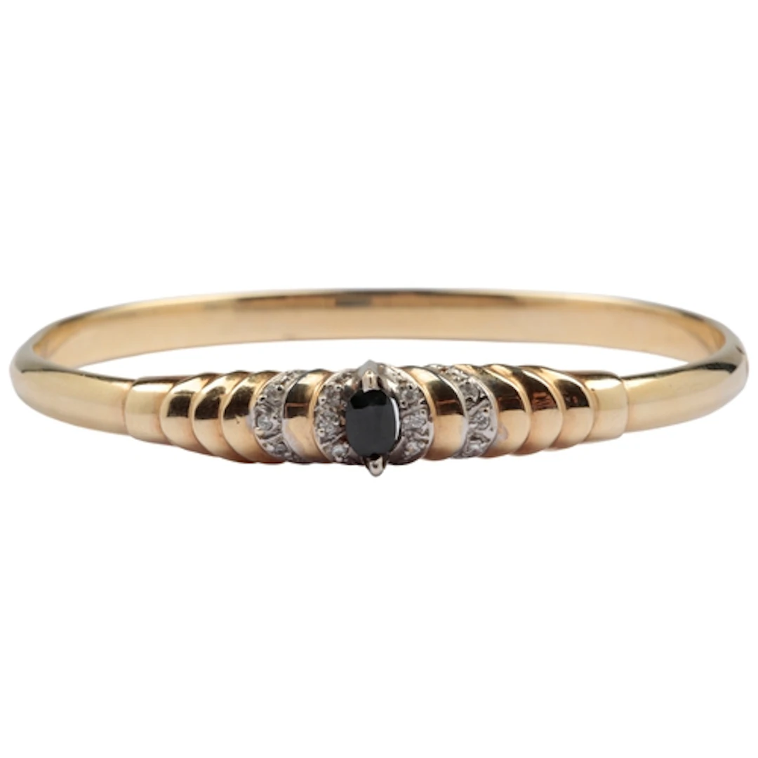 A sapphire bangle, the hinged bangle centring to the front o...