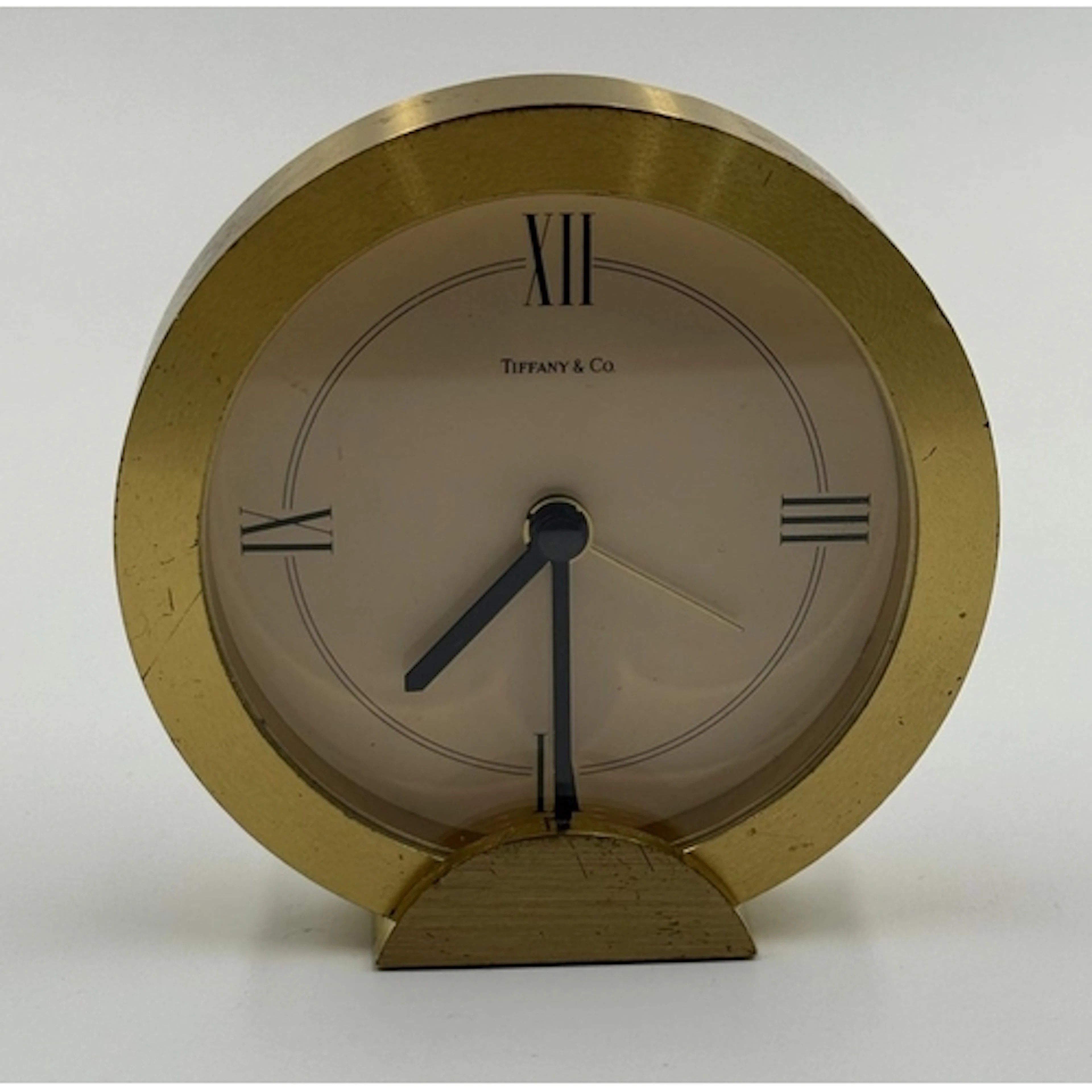 A Tiffany & Co round brass desk clock.