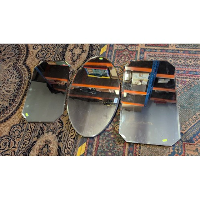 A group of three wall mirrors, comprising an oval mirror and...