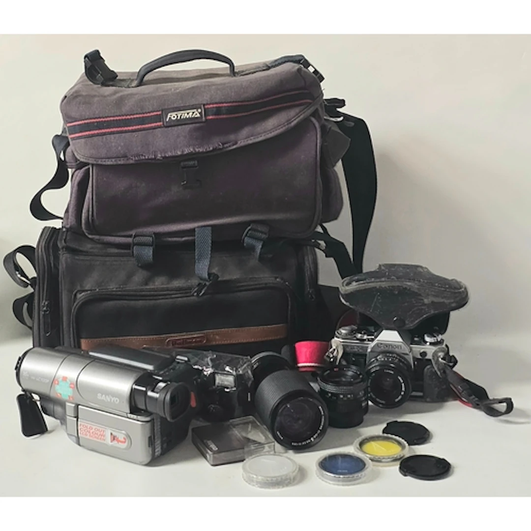 A collection of cameras and lenses to include Canon AE-1 tog...