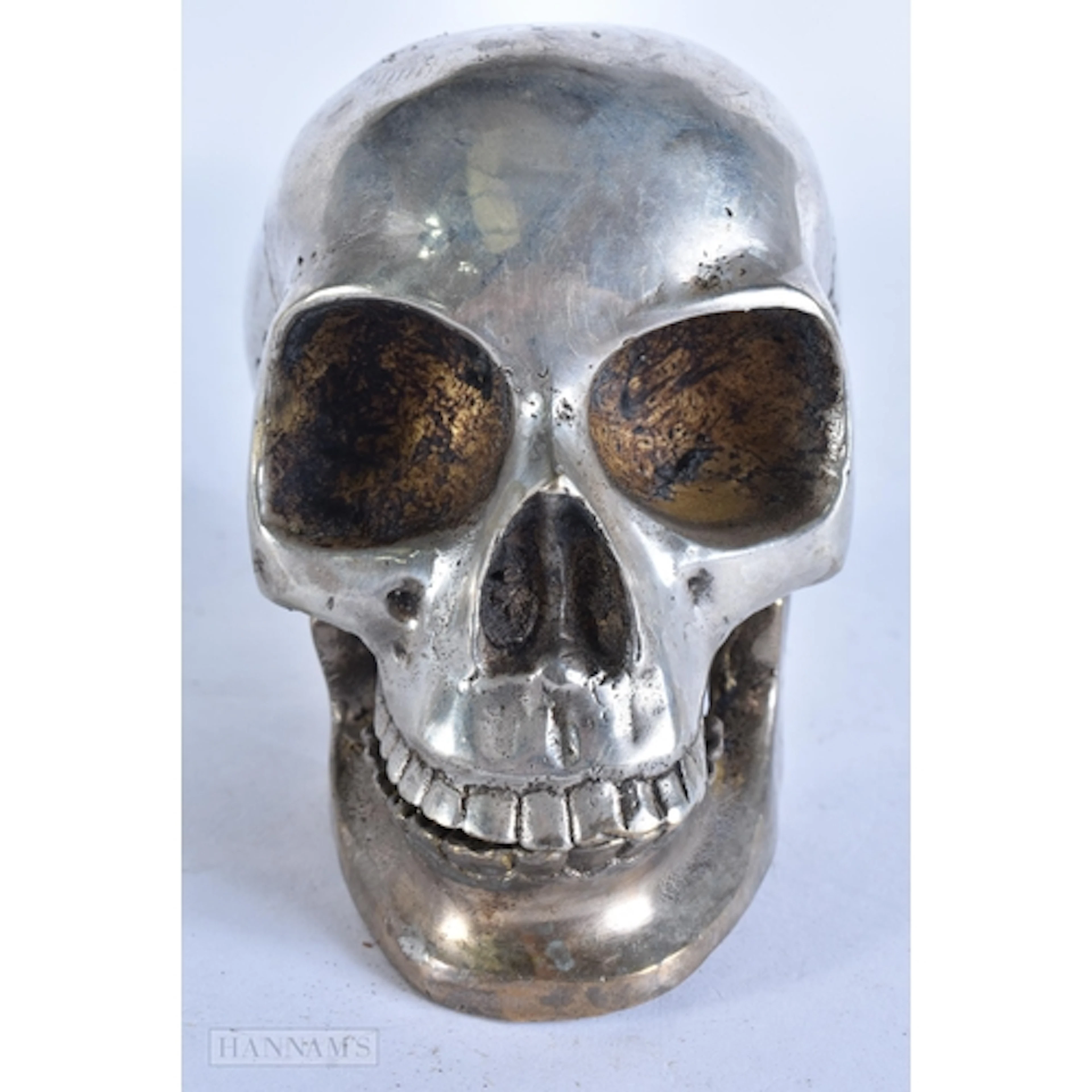 A SILVER PLATED SKULL. 12 cm wide.