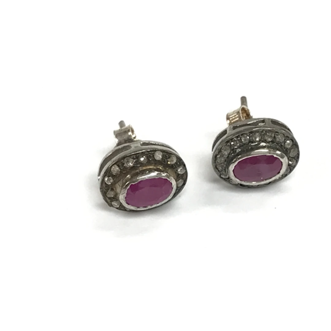 Pair of silver studs set with oval rubies and diamond halos....