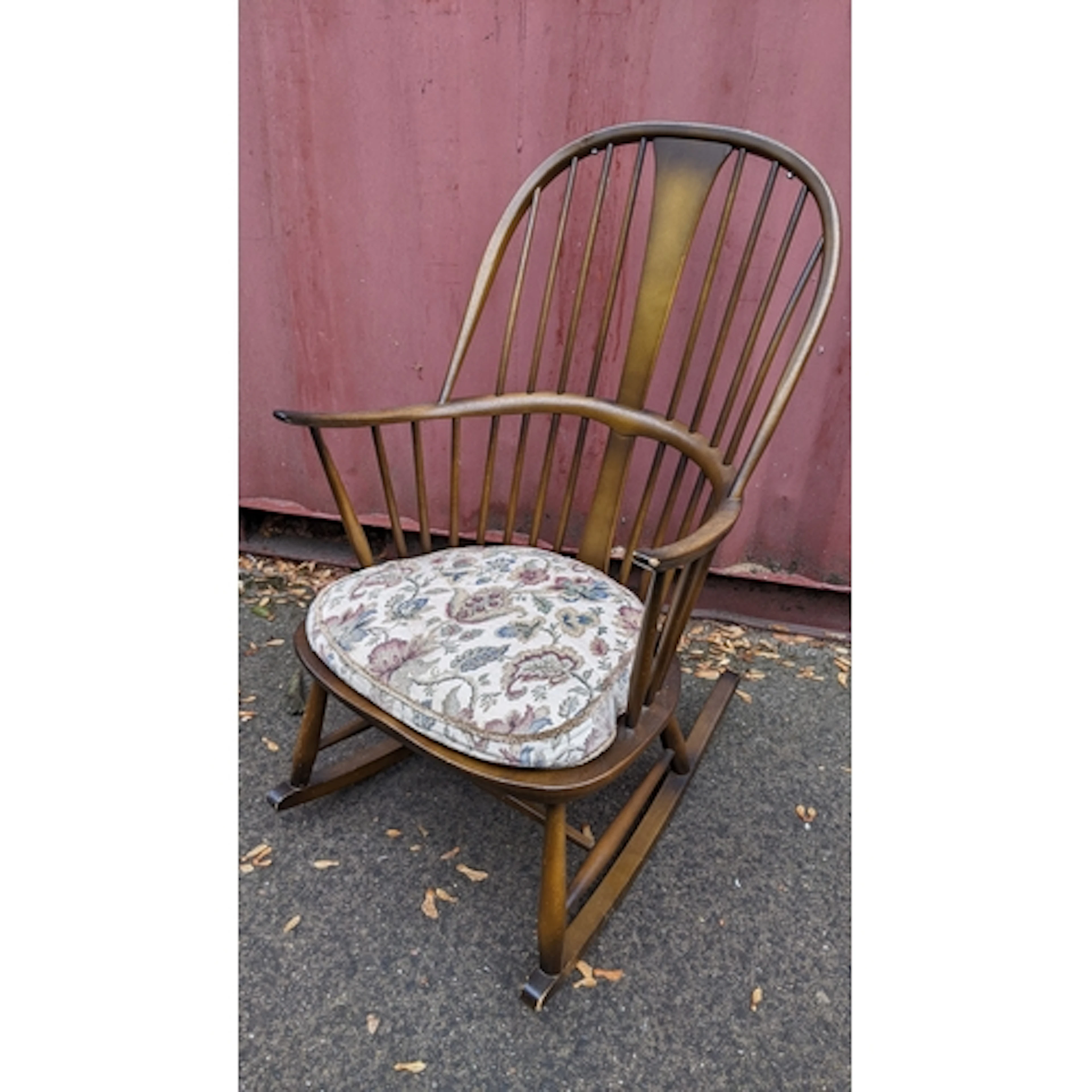 A mid 20th century Ercol stained elm and beech rocking chair...