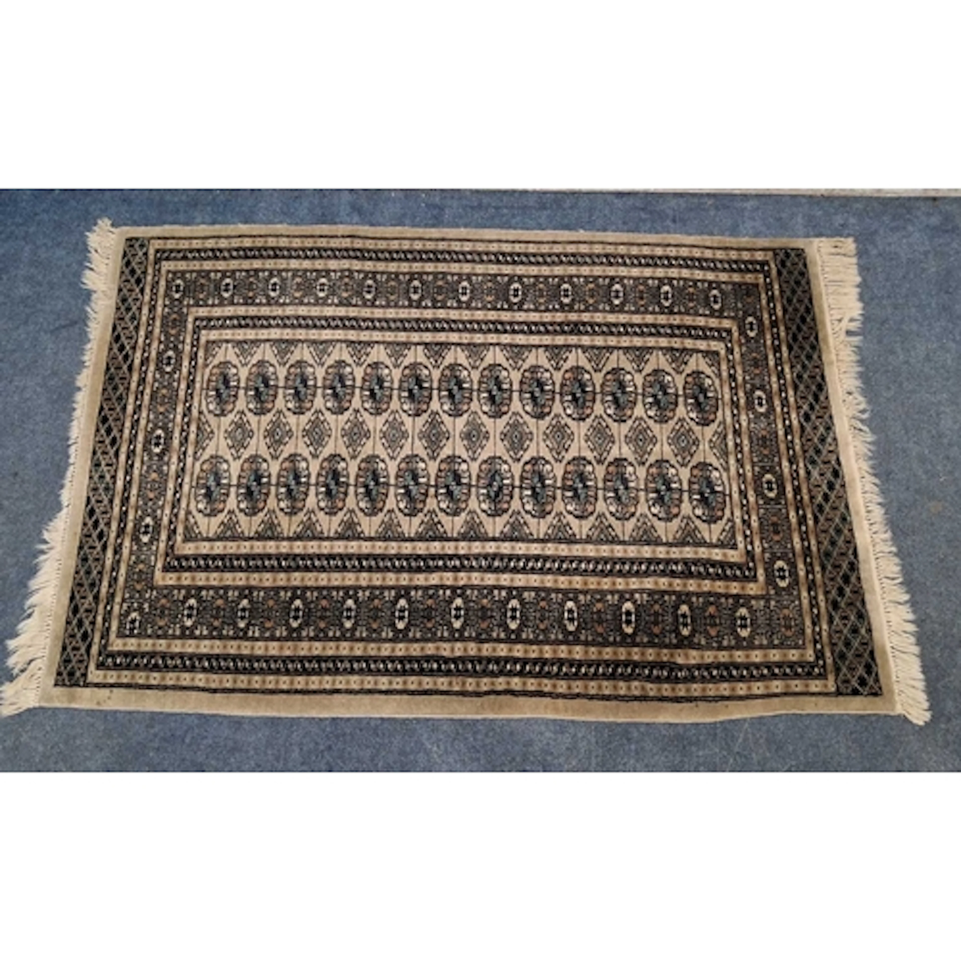 A PAKISTANI BOKHARA RECTANGULAR WOOLLEN RUG, with twenty-six...